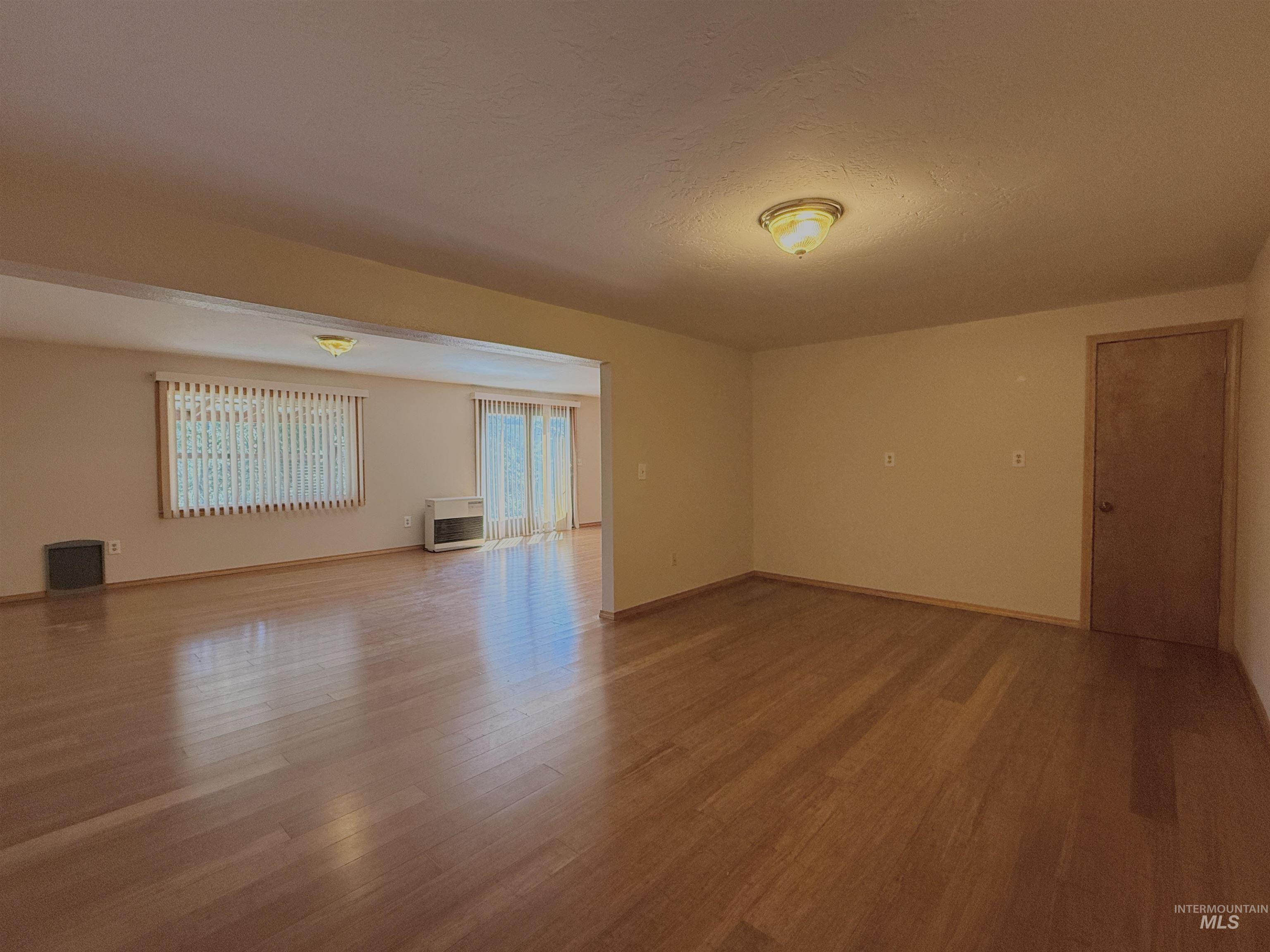 Spare room featuring wood finished floors and a textured ceiling
