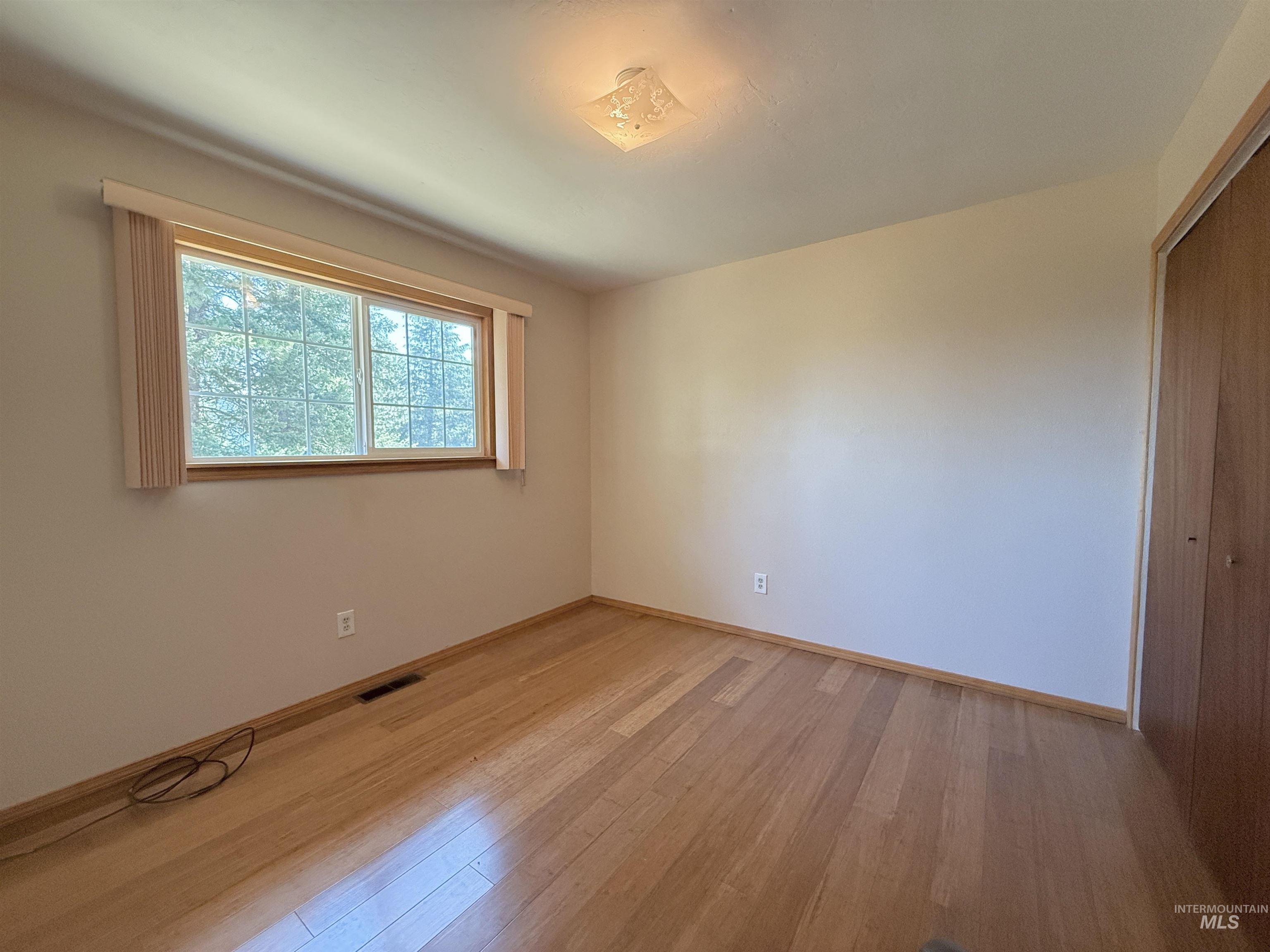Empty room featuring light wood-style flooring and baseboards