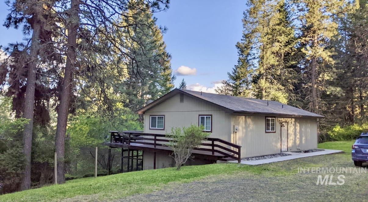 View of front of property featuring a deck and a front yard