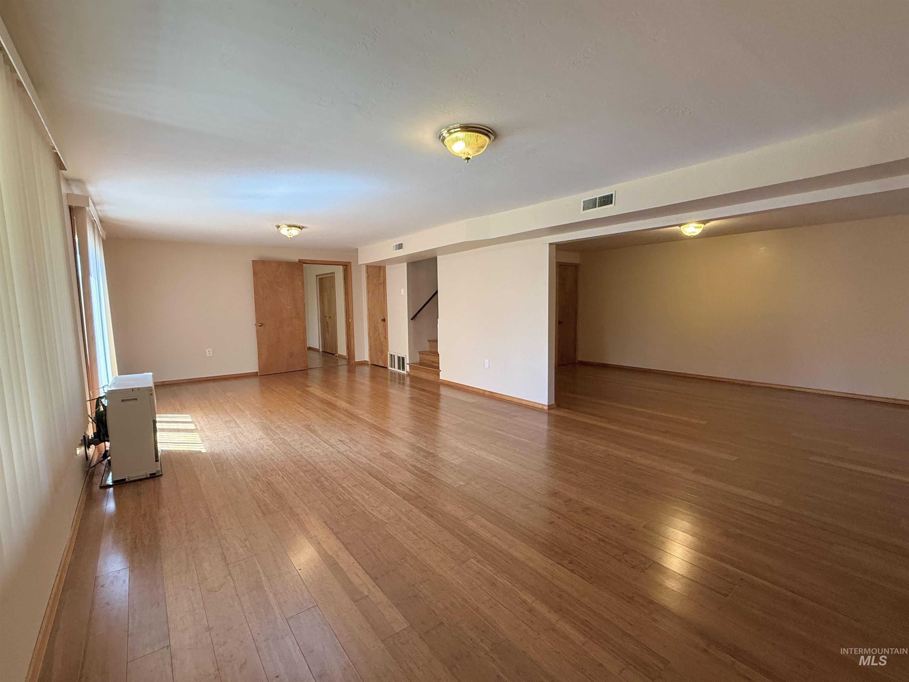 Empty room featuring hardwood / wood-style floors and stairs