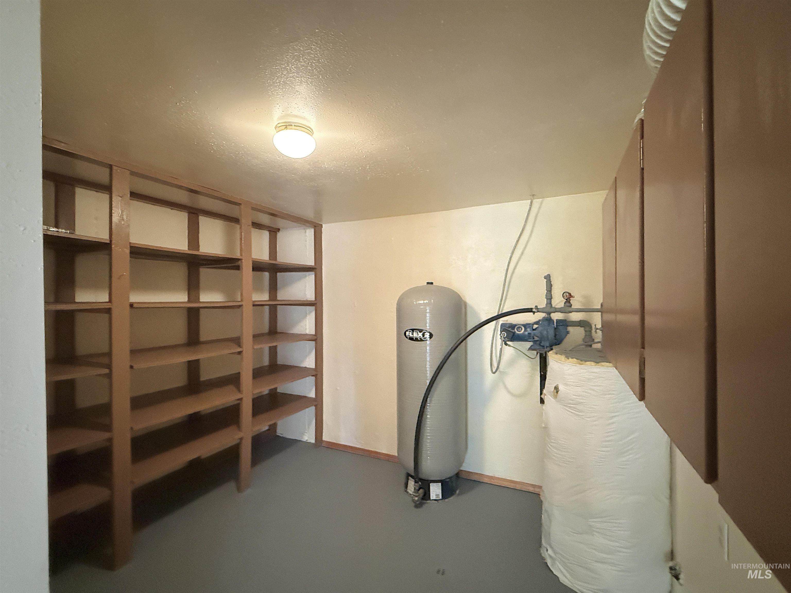 Below grade area featuring a textured ceiling and a water pressure tank