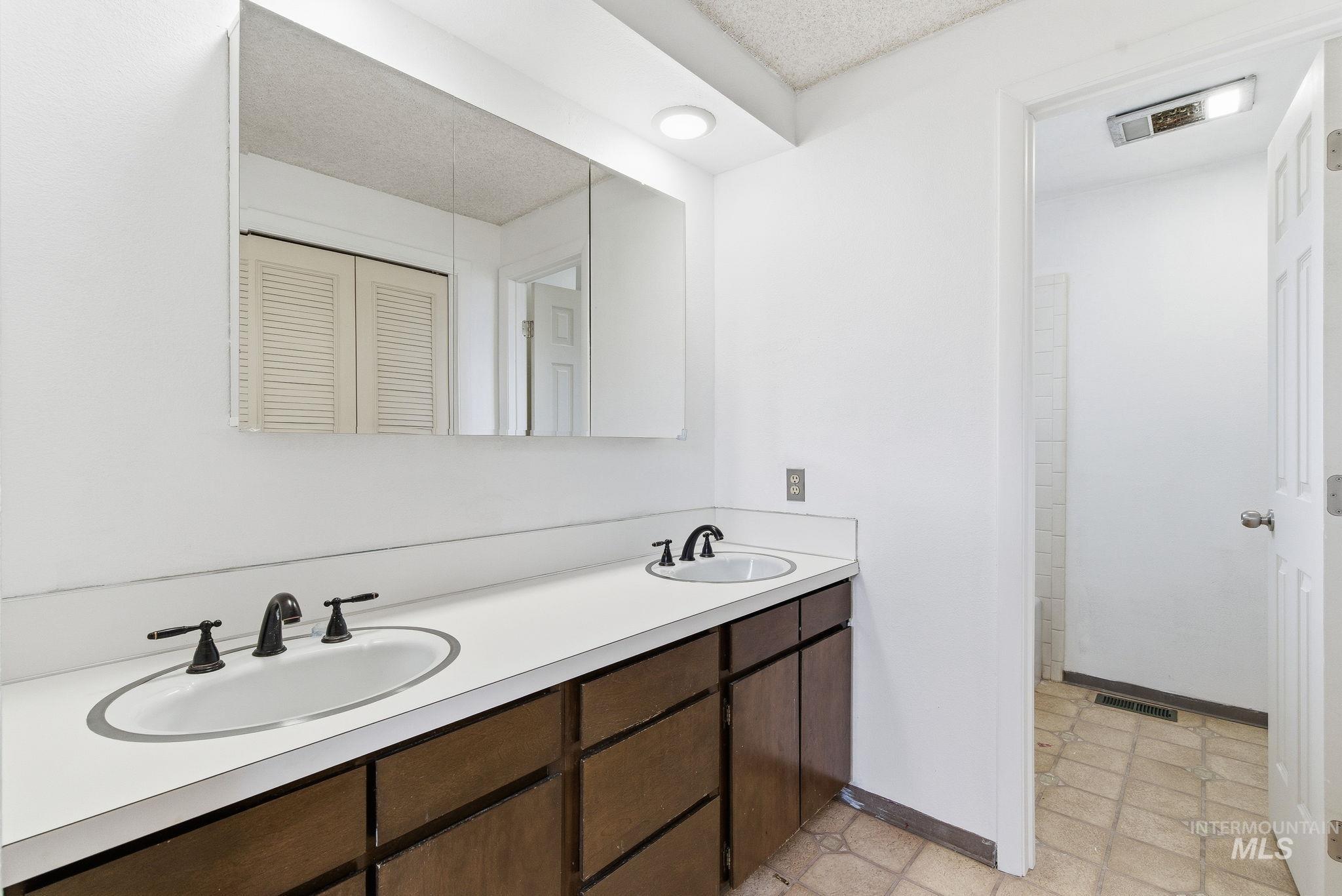 Full bathroom featuring double vanity and a closet