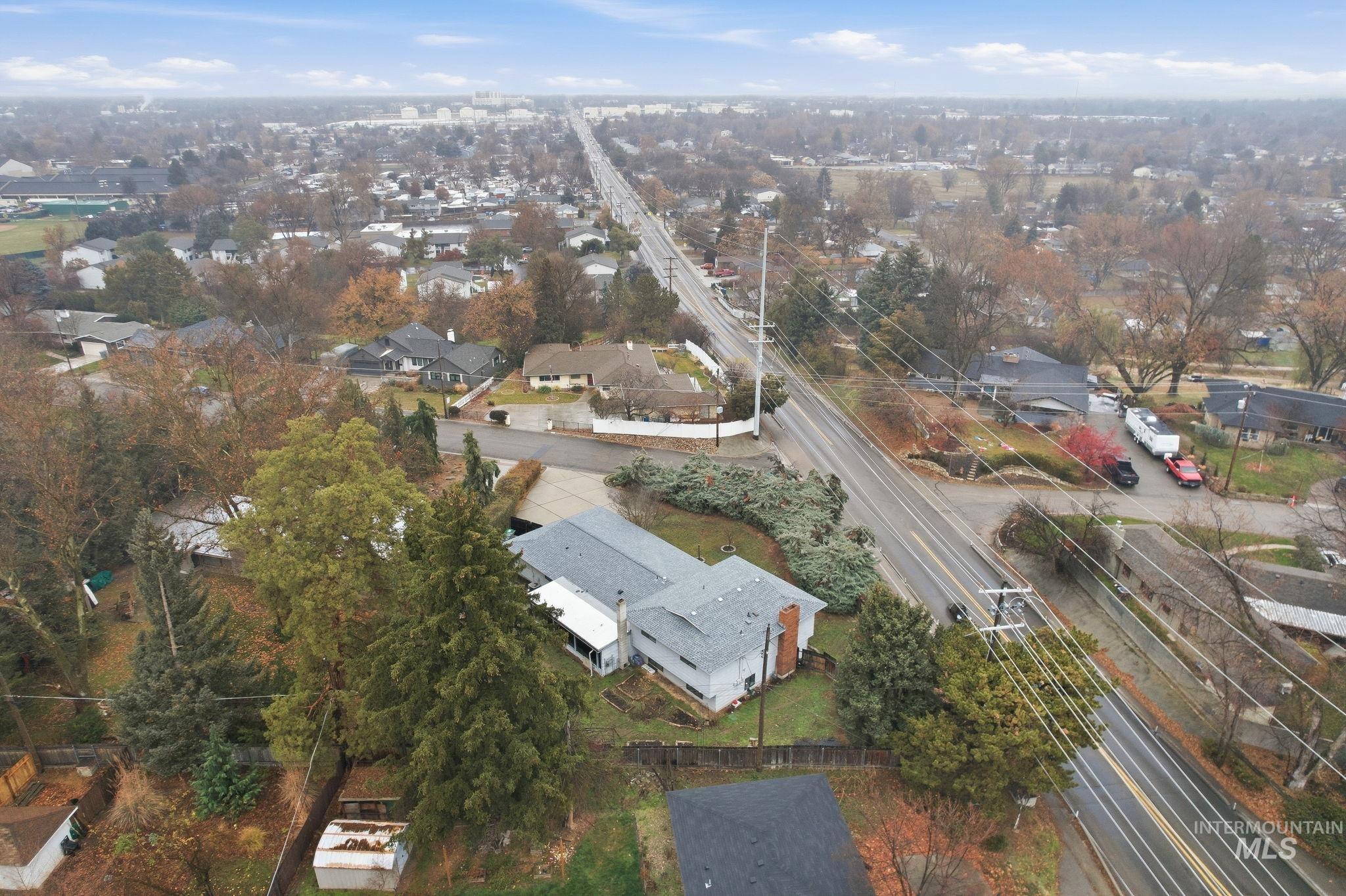 Aerial view of property and surrounding area with nearby suburban area