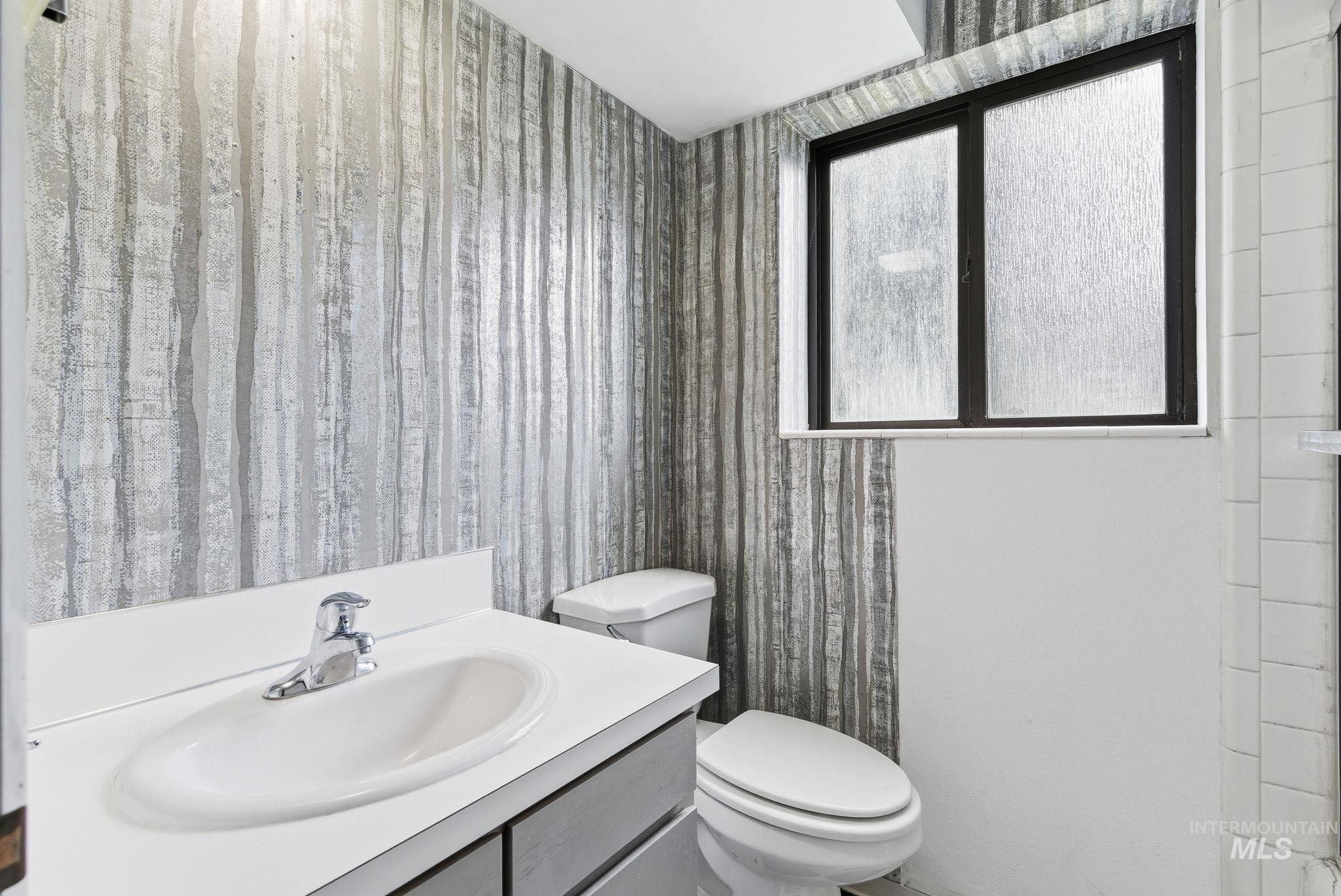 Bathroom featuring vanity and wallpapered walls