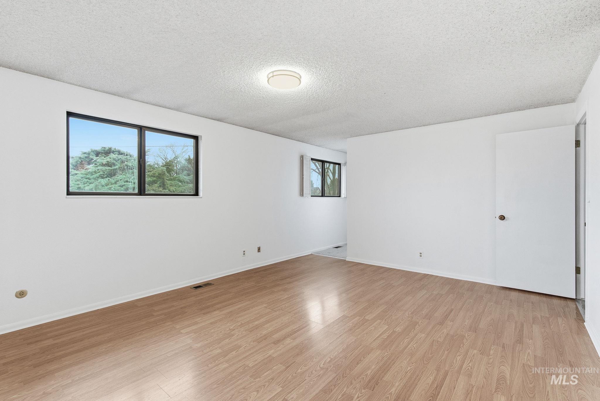 Unfurnished room featuring a textured ceiling and light wood-type flooring
