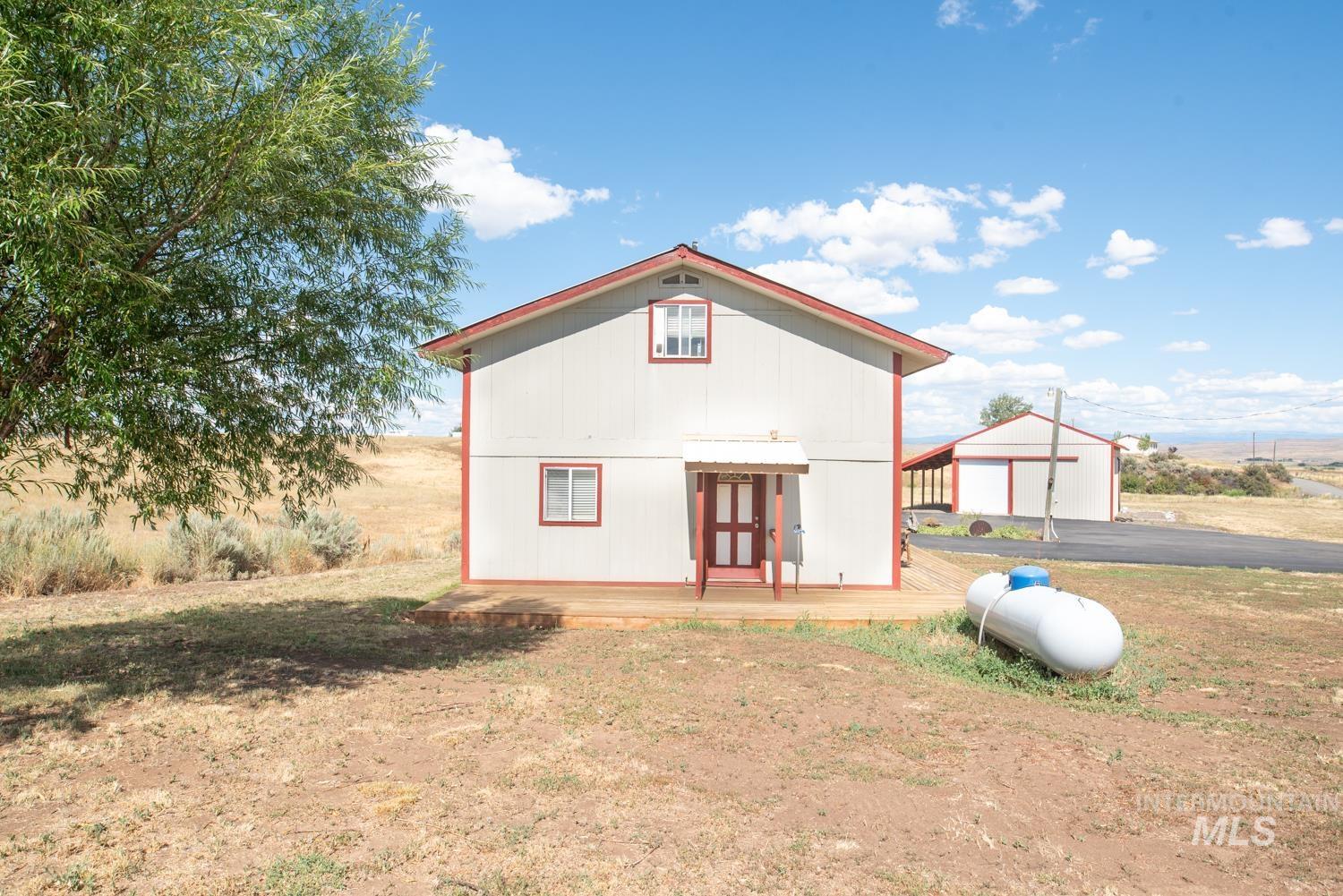 Rear view of property with an outbuilding, a garage, and driveway