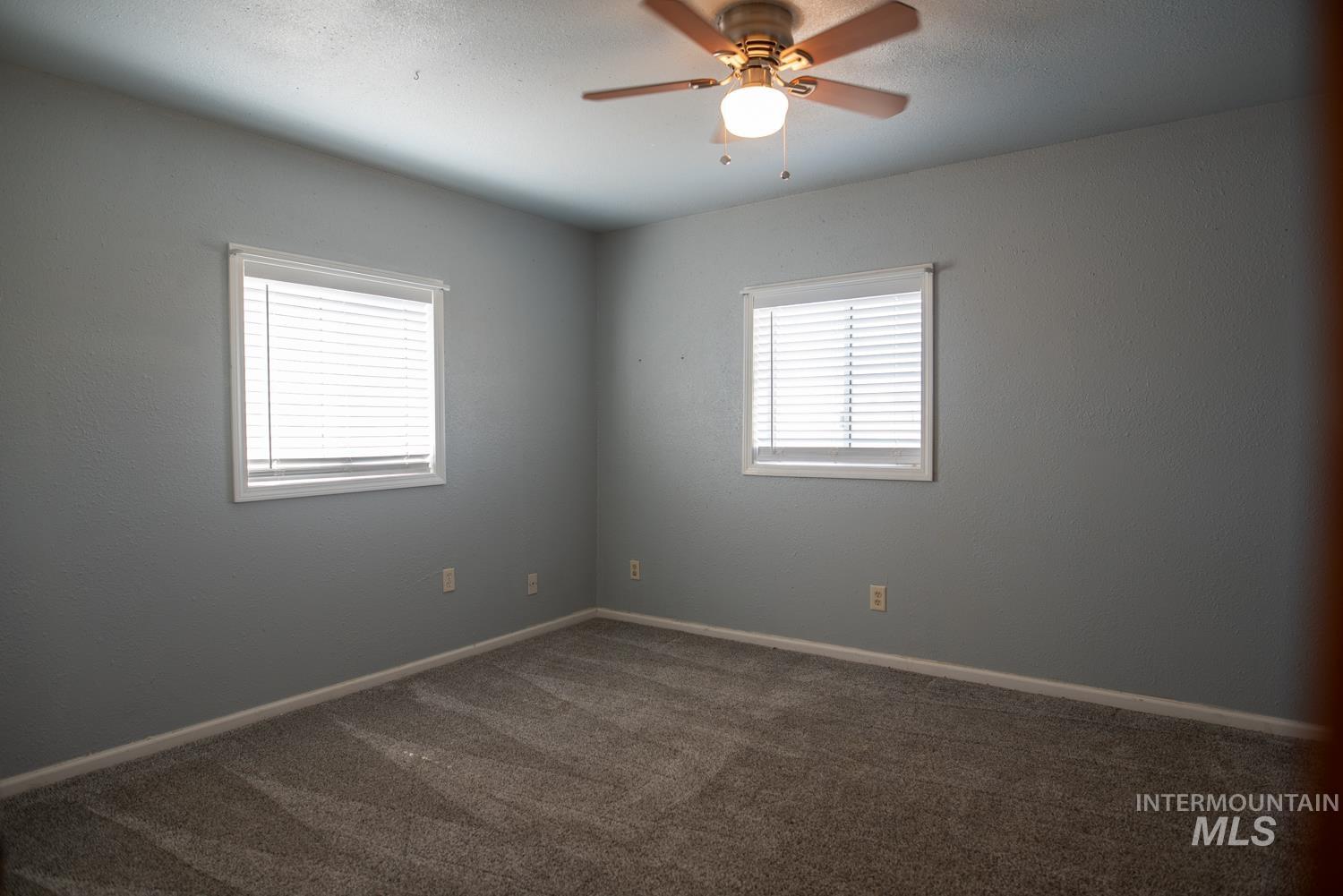 Empty room with carpet floors and a ceiling fan