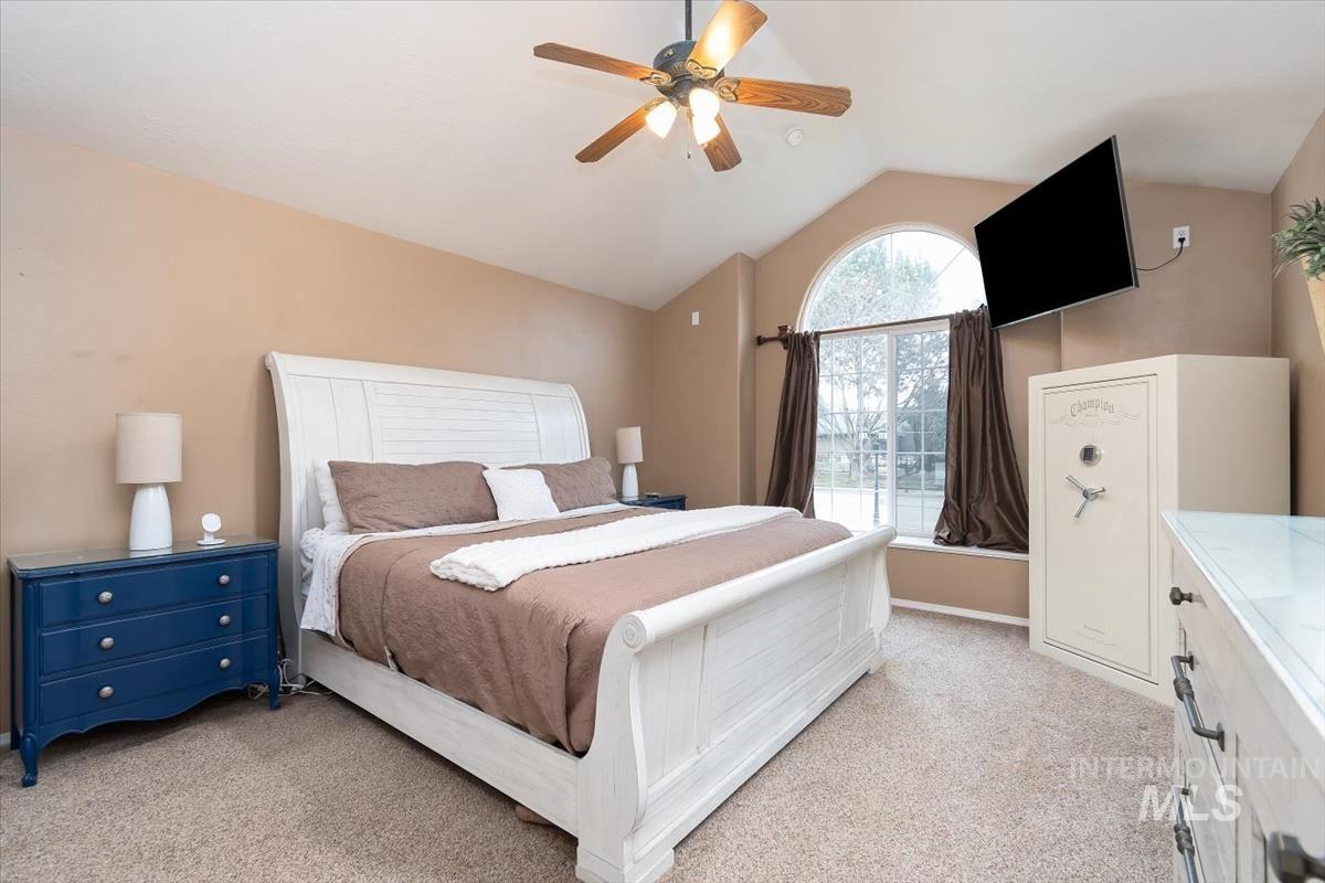 Vaulted ceiling featuring a ceiling fan with light fixture