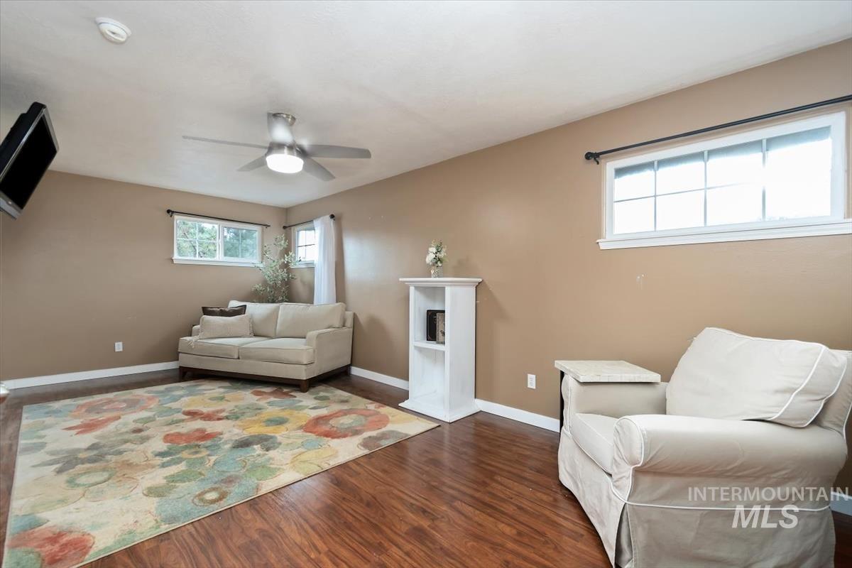 Living space featuring wood-finish flooring, neutral wall tones, and white trim on the upper level. Could be a private office, sitting room or gaming room