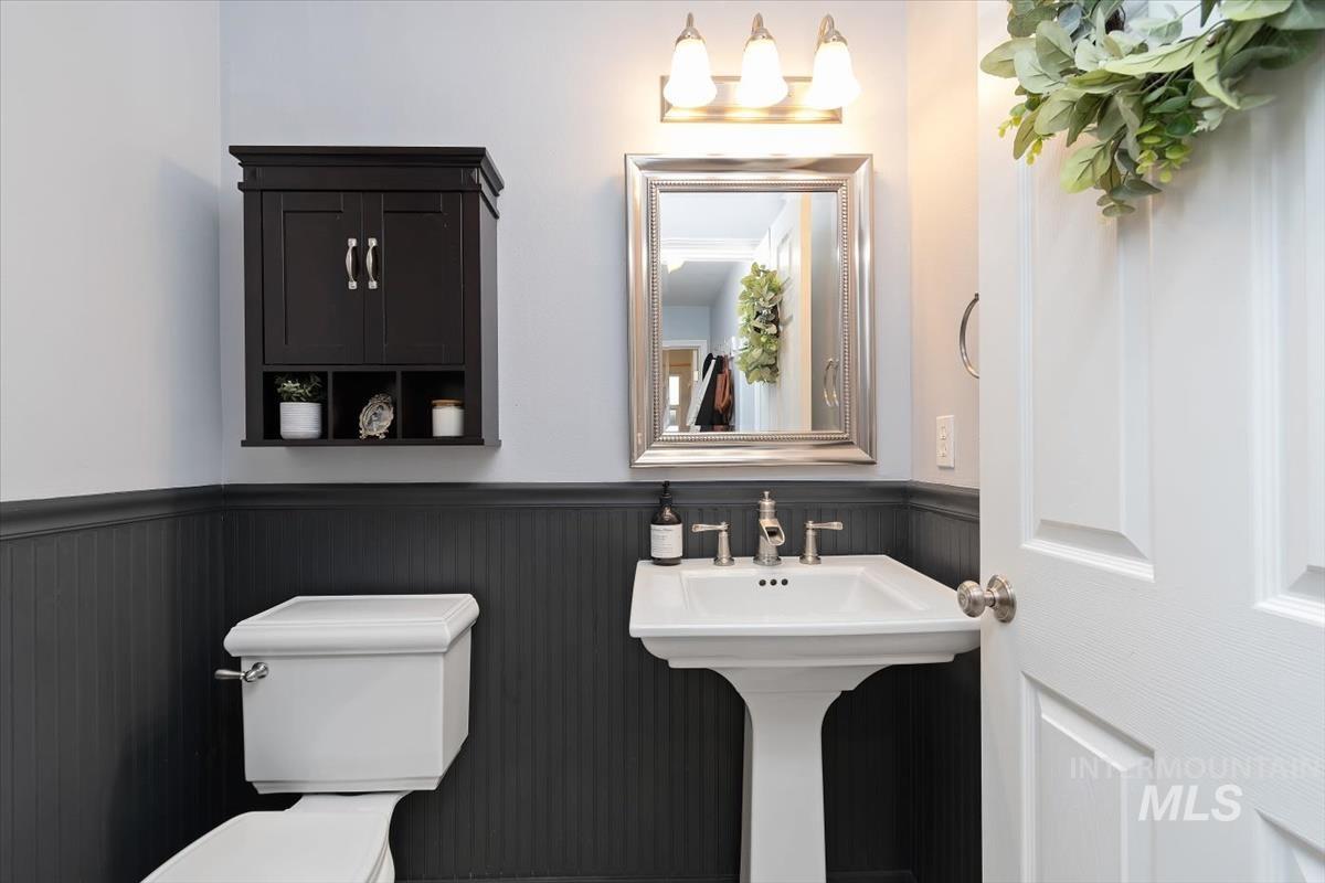 Pedestal sink with polished chrome faucet and framed mirror on main floor