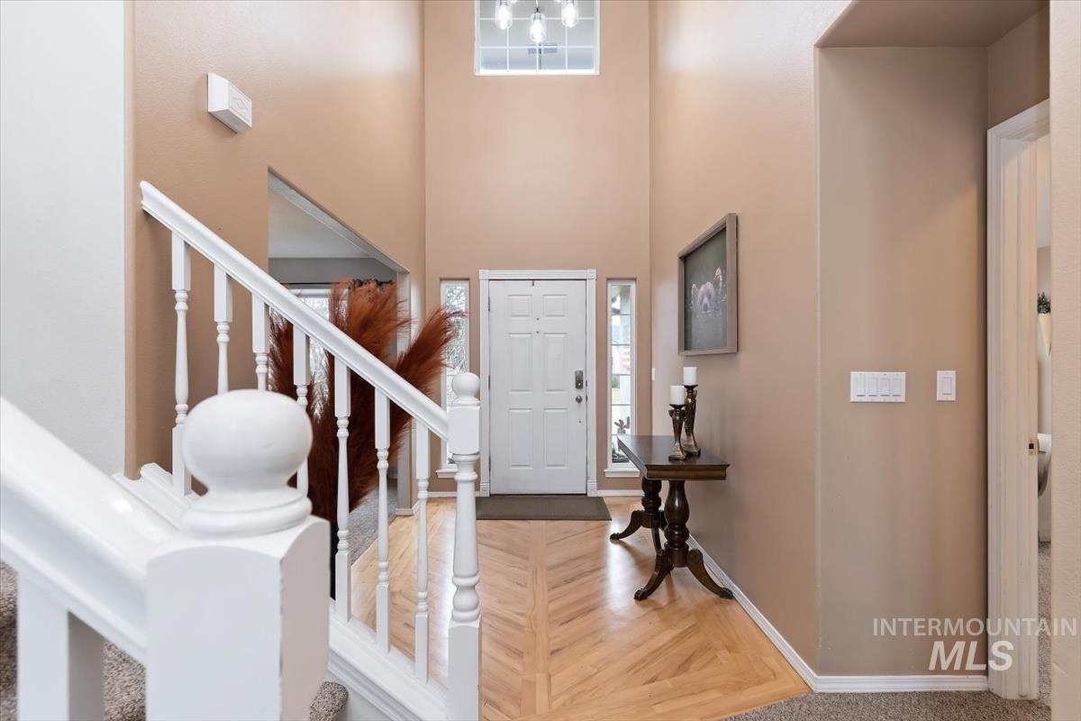Two-story entryway with a decorative front door, flanking side windows, and transom window above