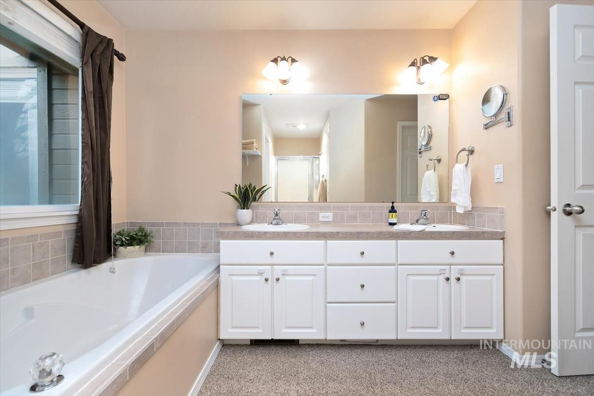 Double vanity with under-sink storage, integrated dual sinks, and large wall-mounted mirror