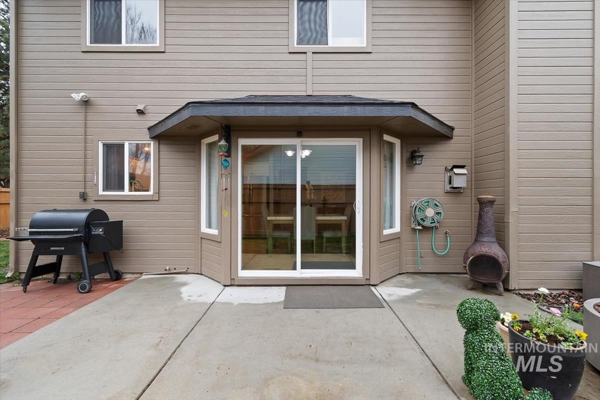 Rear exterior patio area featuring concrete and paver surfaces