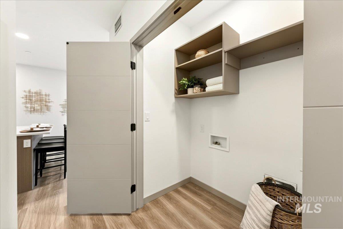 Laundry area featuring light wood-style floors and washer hookup