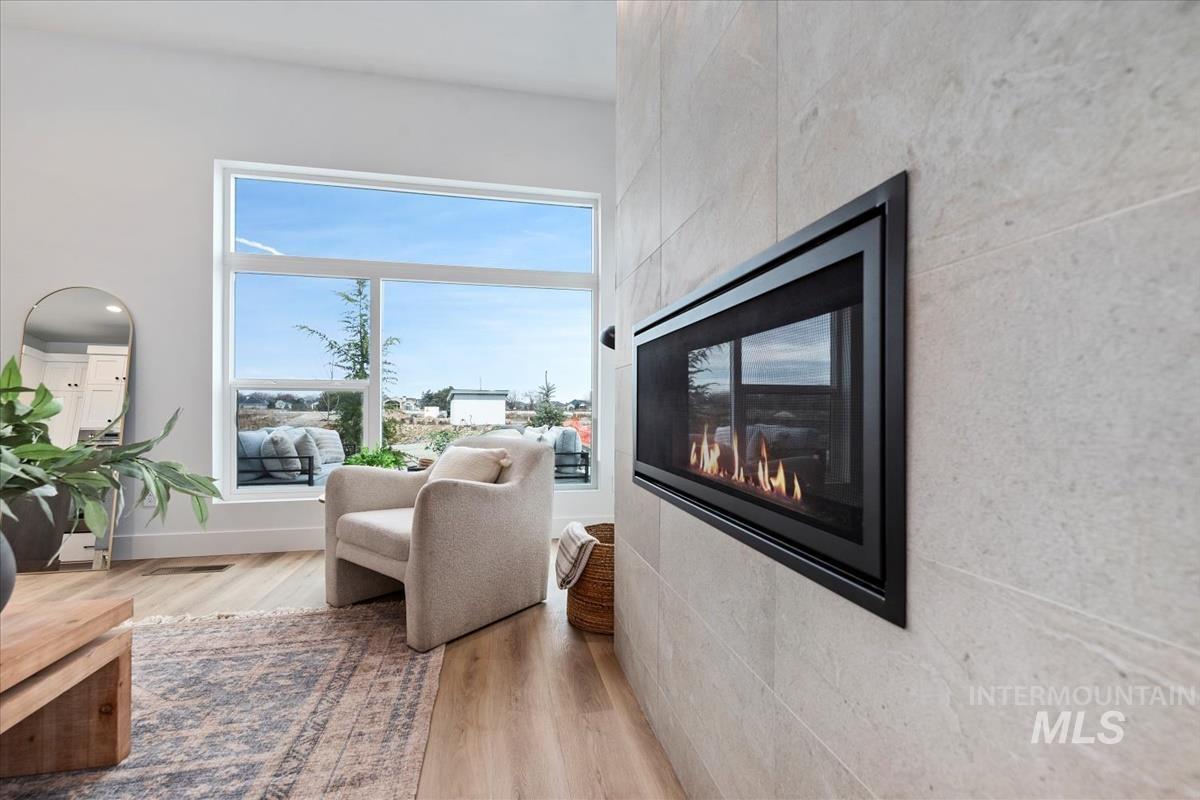Sitting room with light wood finished floors and a multi sided fireplace