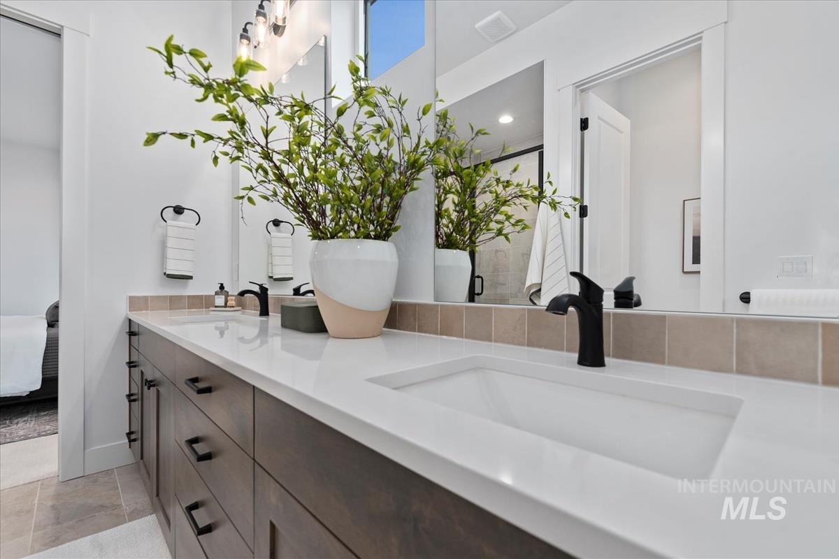 Ensuite bathroom featuring double vanity and a stall shower