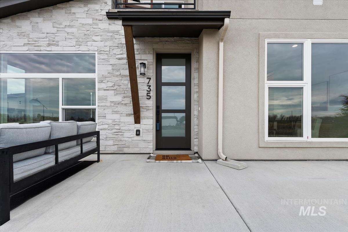 Entrance to property featuring stone siding and stucco siding