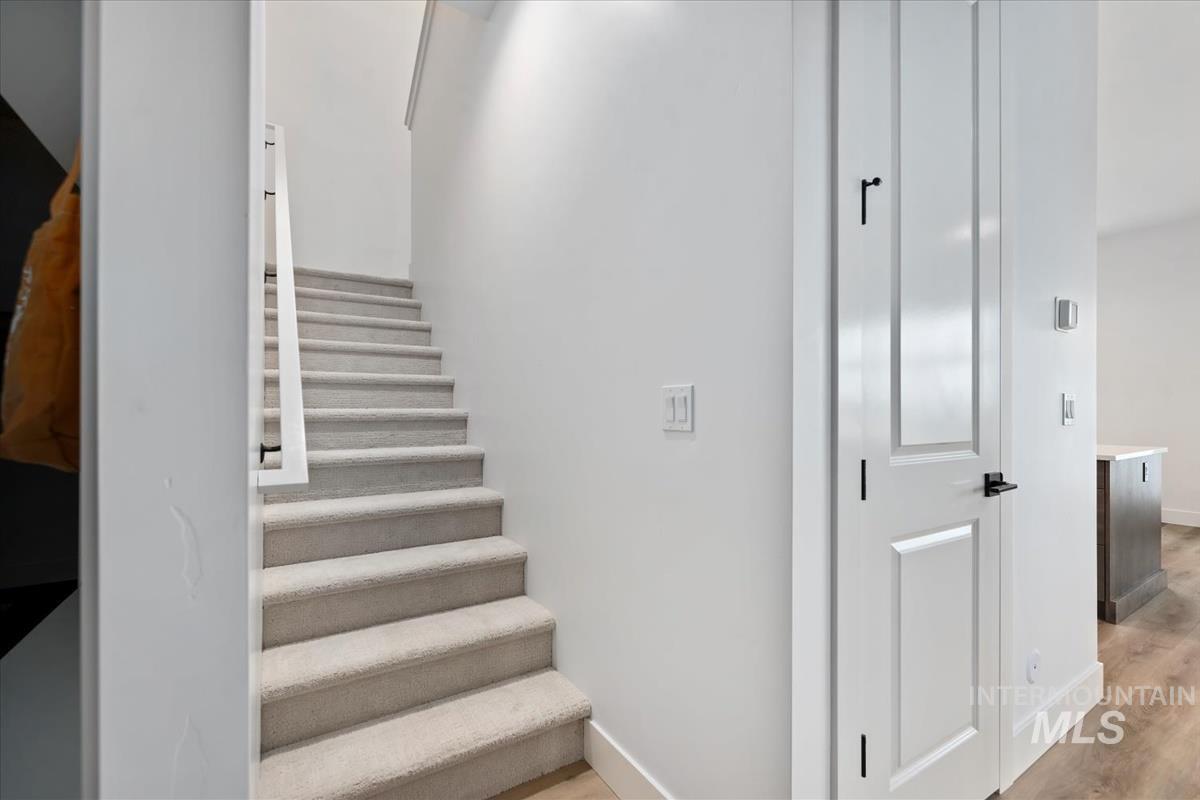 Stairs featuring wood finished floors and baseboards