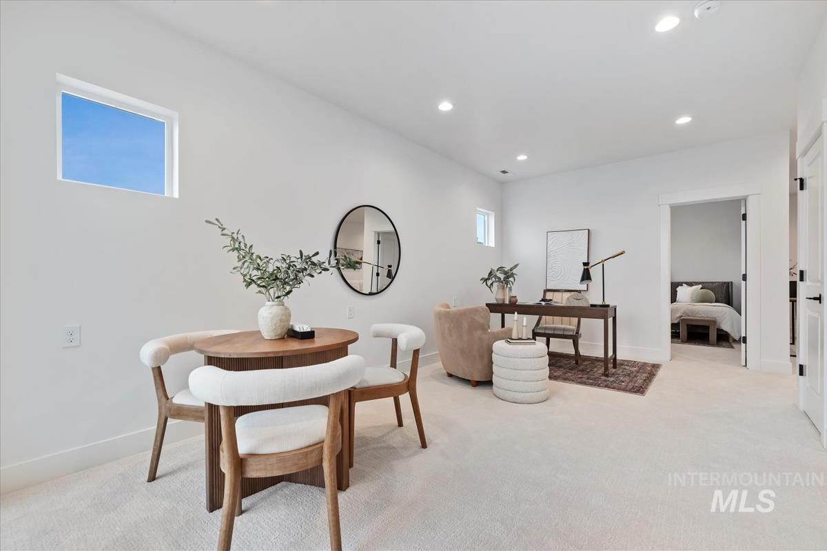 Dining area with light colored carpet and recessed lighting