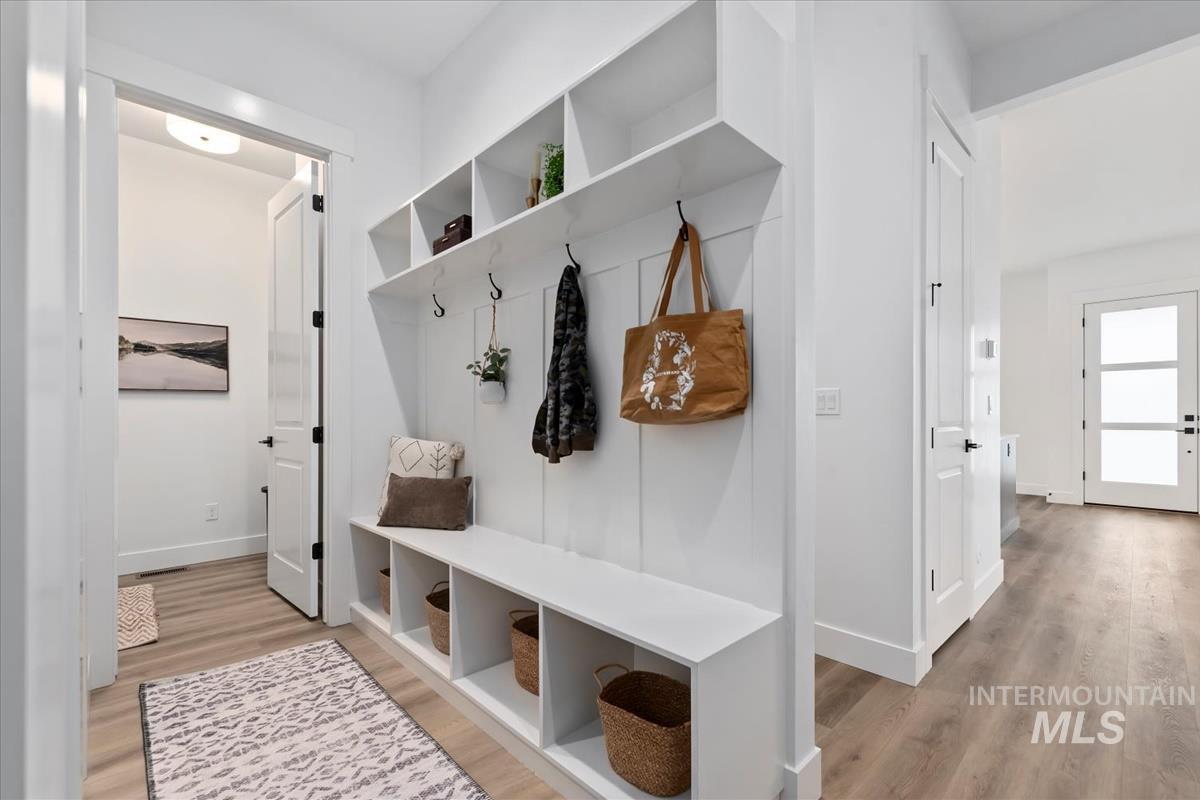 Mudroom featuring light wood-style flooring and baseboards