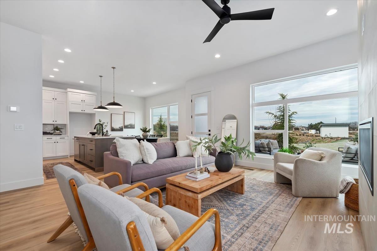 Living room with recessed lighting, light wood-type flooring, and ceiling fan