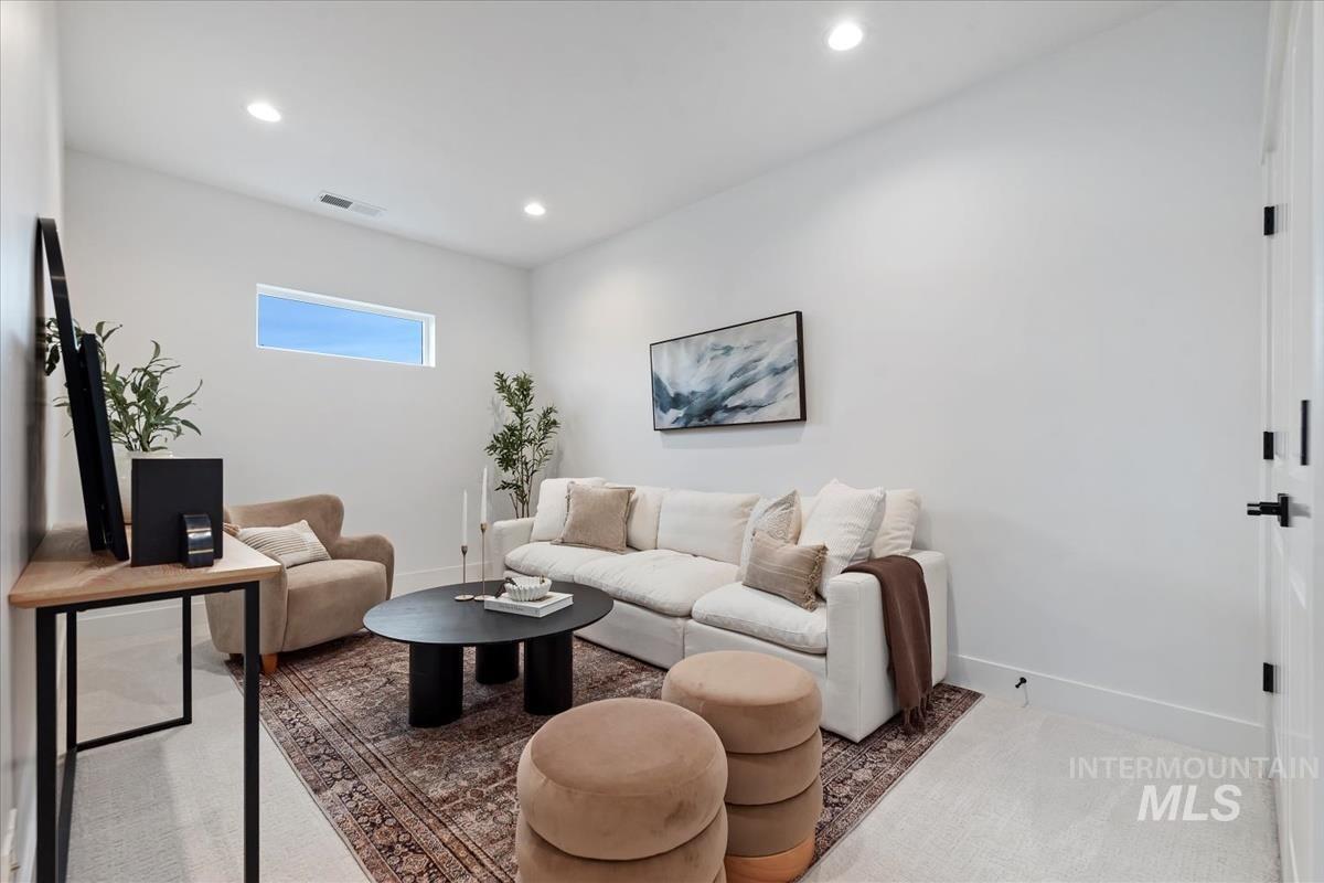 Carpeted living area featuring baseboards and recessed lighting