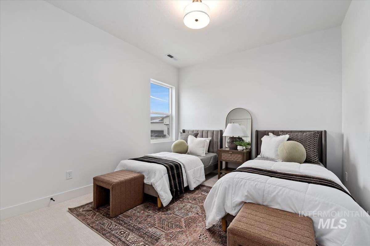 Bedroom featuring carpet and baseboards