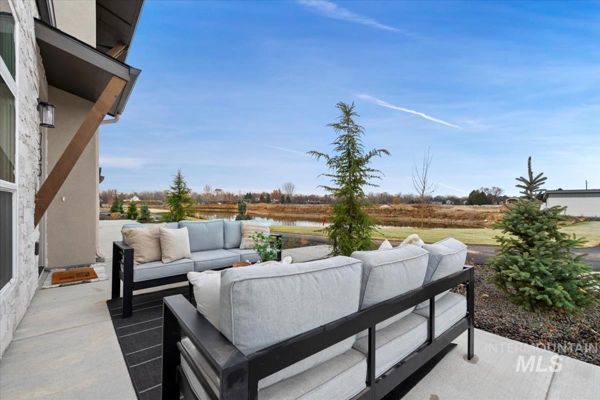 View of patio with an outdoor hangout area and a water view