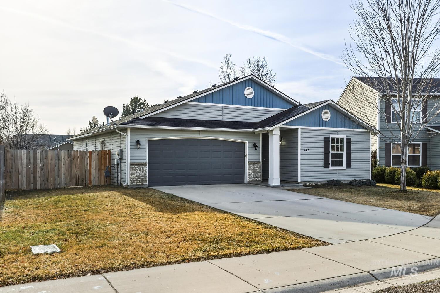View of front facade featuring driveway and an attached garage