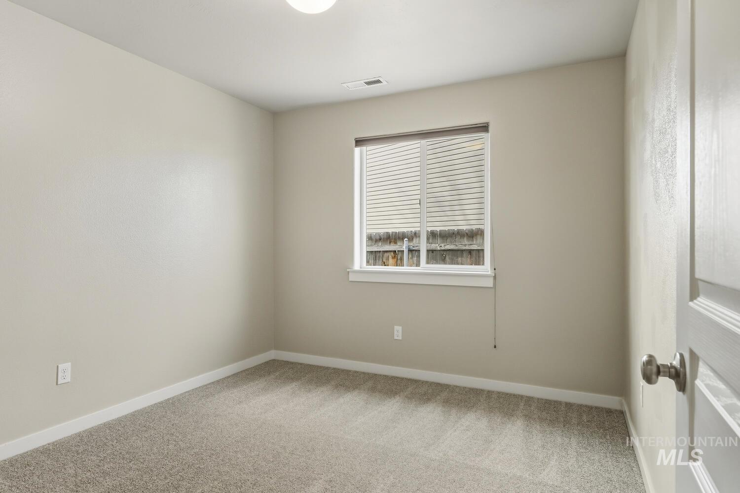 Empty room featuring light carpet and baseboards