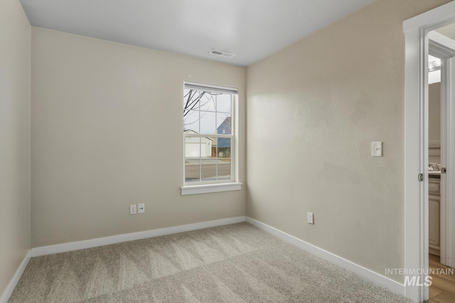 Spare room featuring baseboards and light carpet