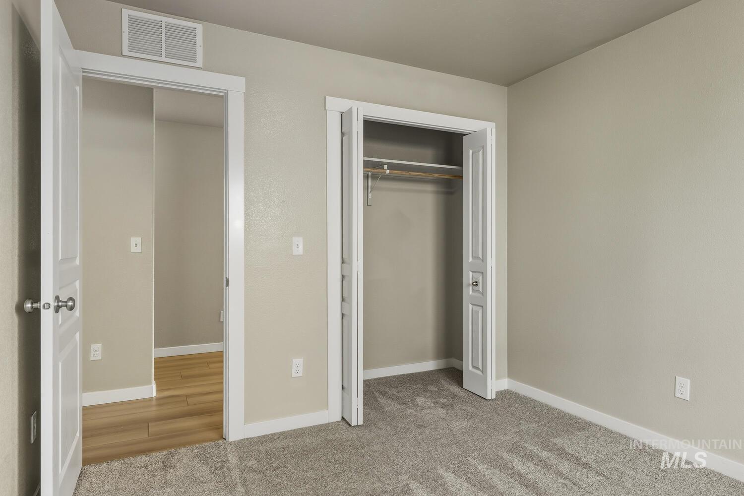 Unfurnished bedroom with light carpet and a closet