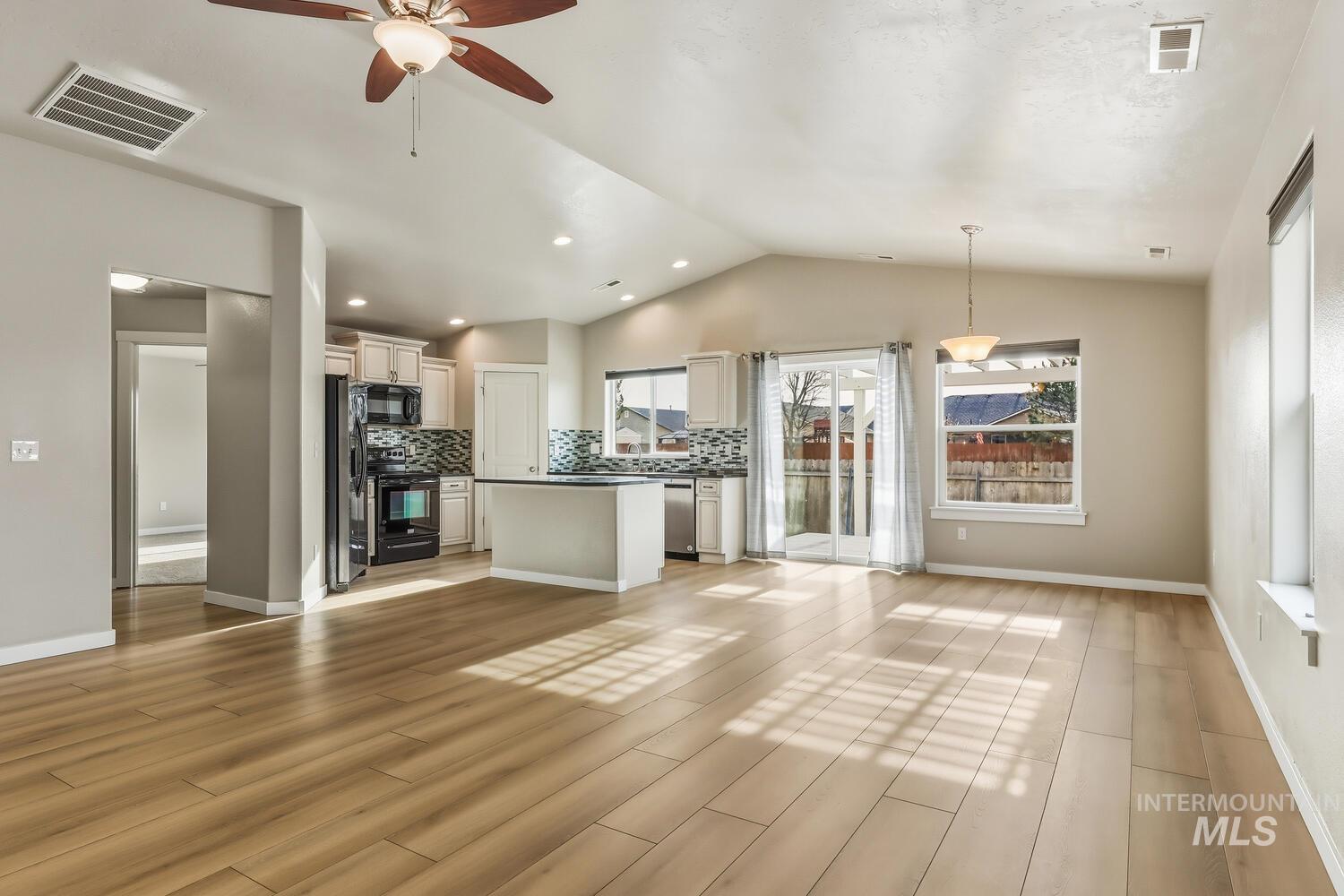 Unfurnished living room featuring light wood finished floors, ceiling fan, vaulted ceiling, and recessed lighting