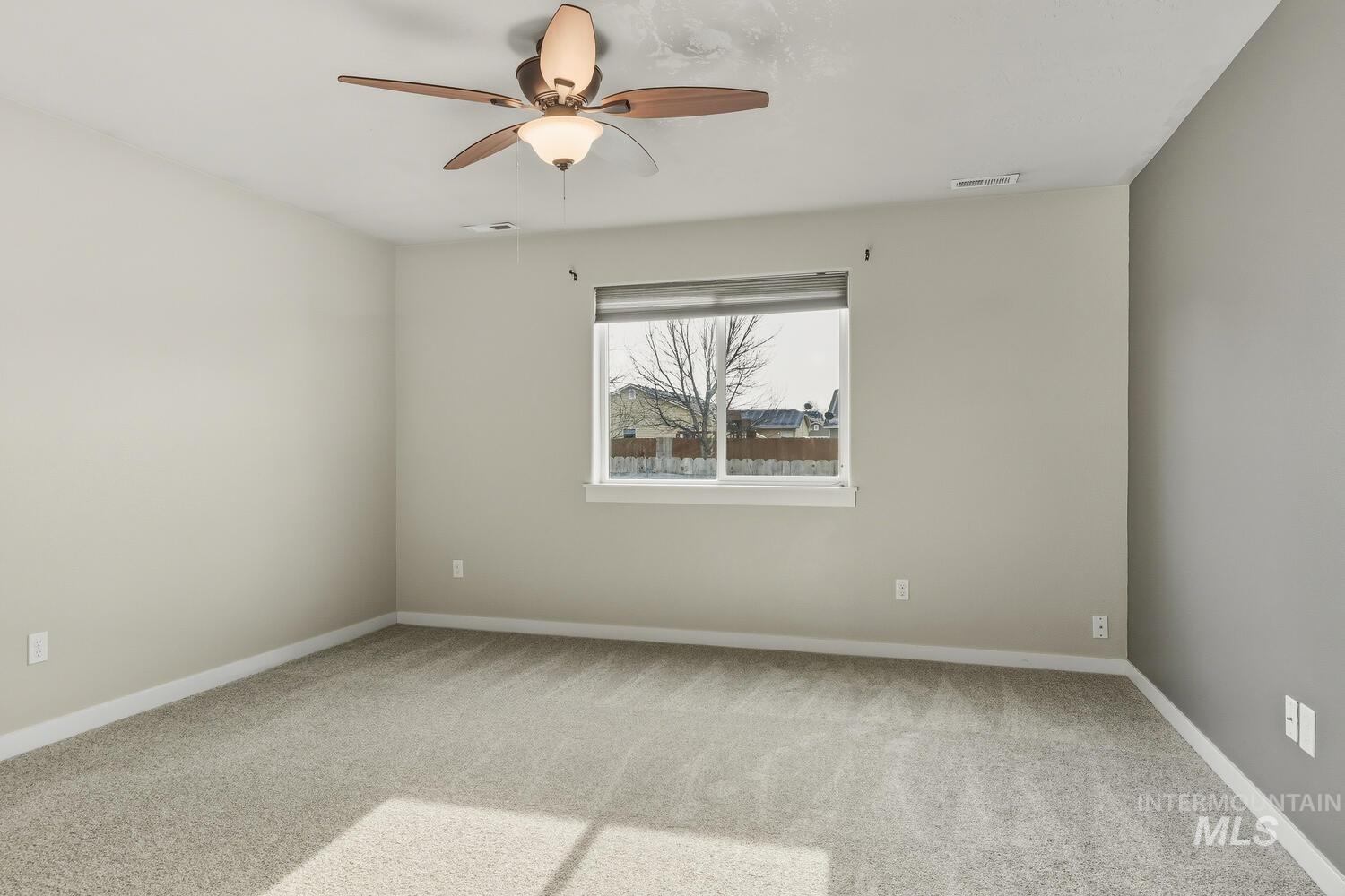 Unfurnished room with light colored carpet and a ceiling fan
