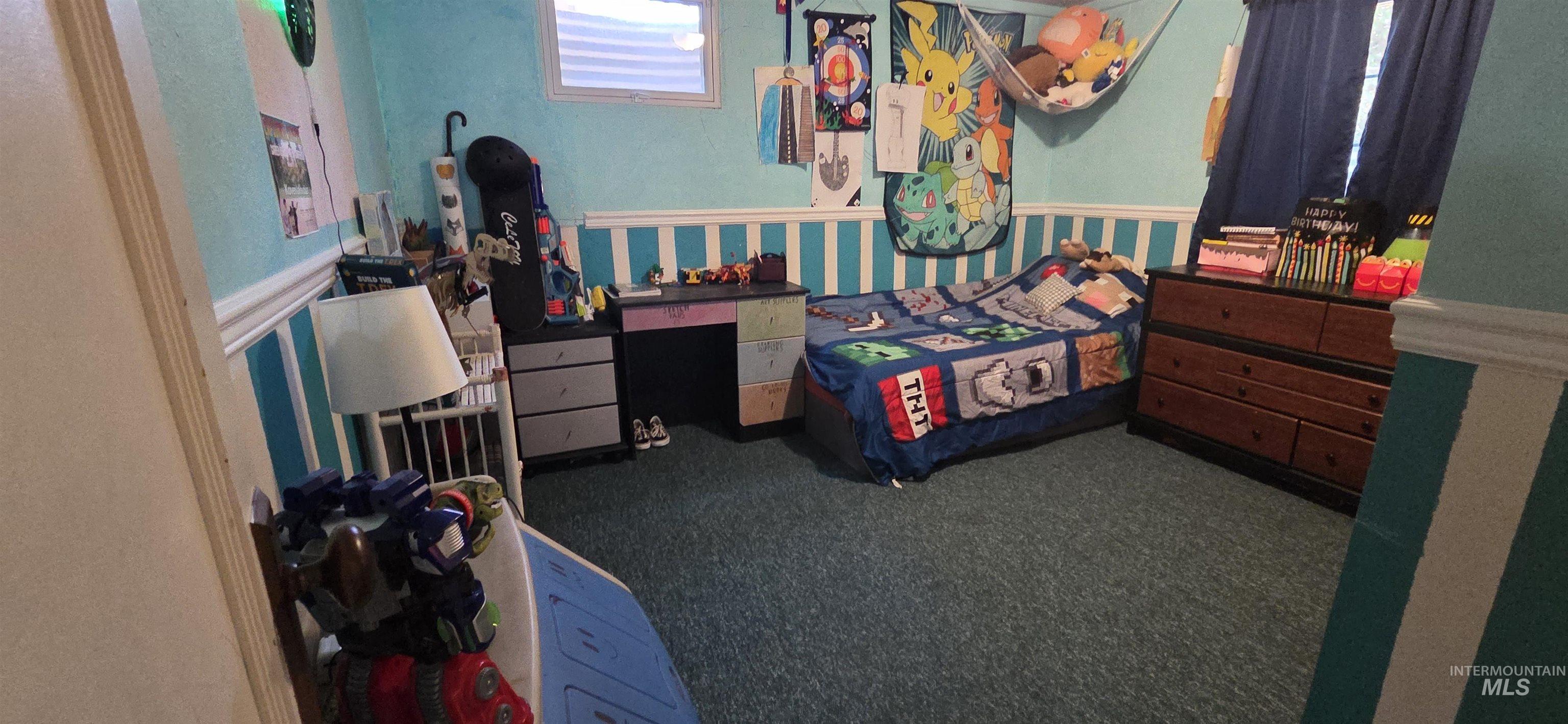 Bedroom featuring carpet flooring, wainscoting, and wallpapered walls