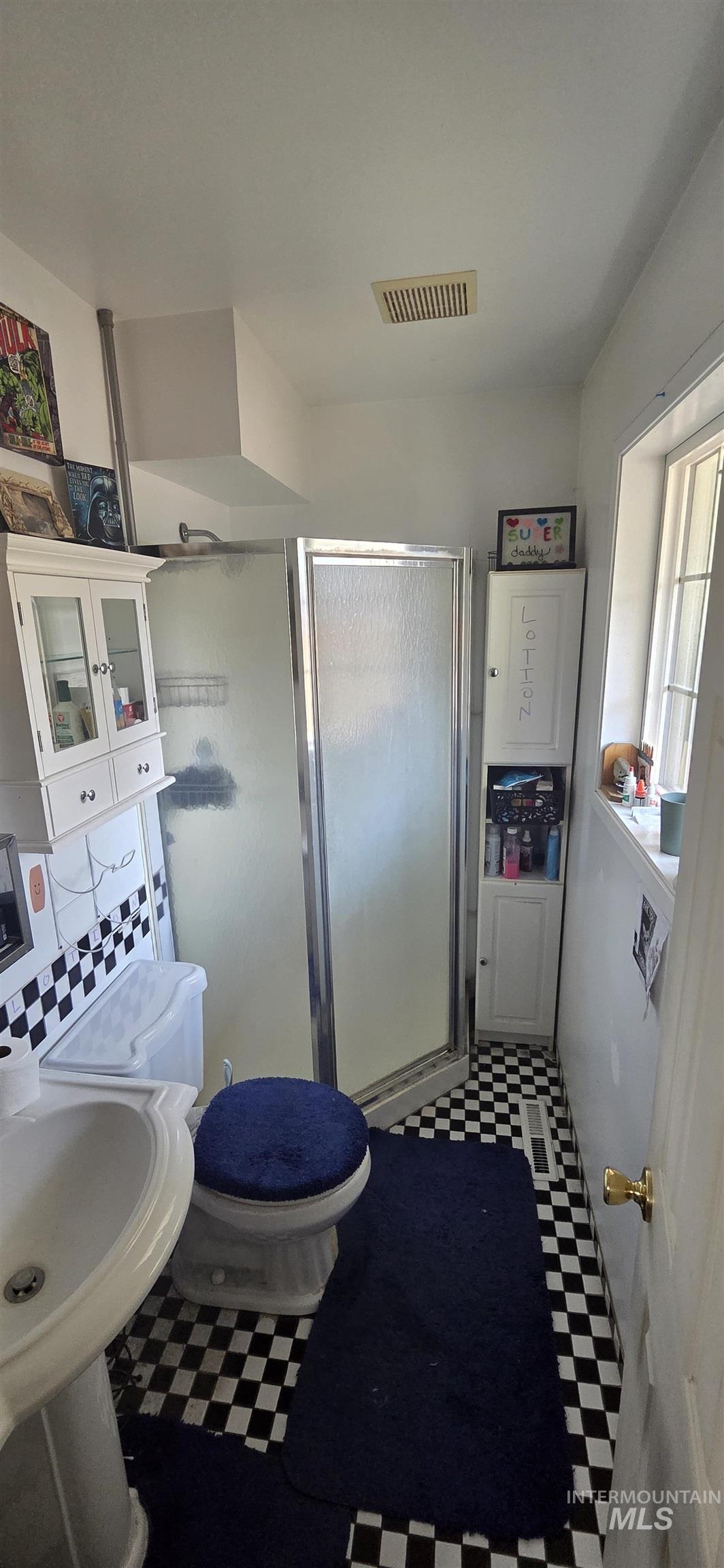 Bathroom with tile patterned floors and a stall shower