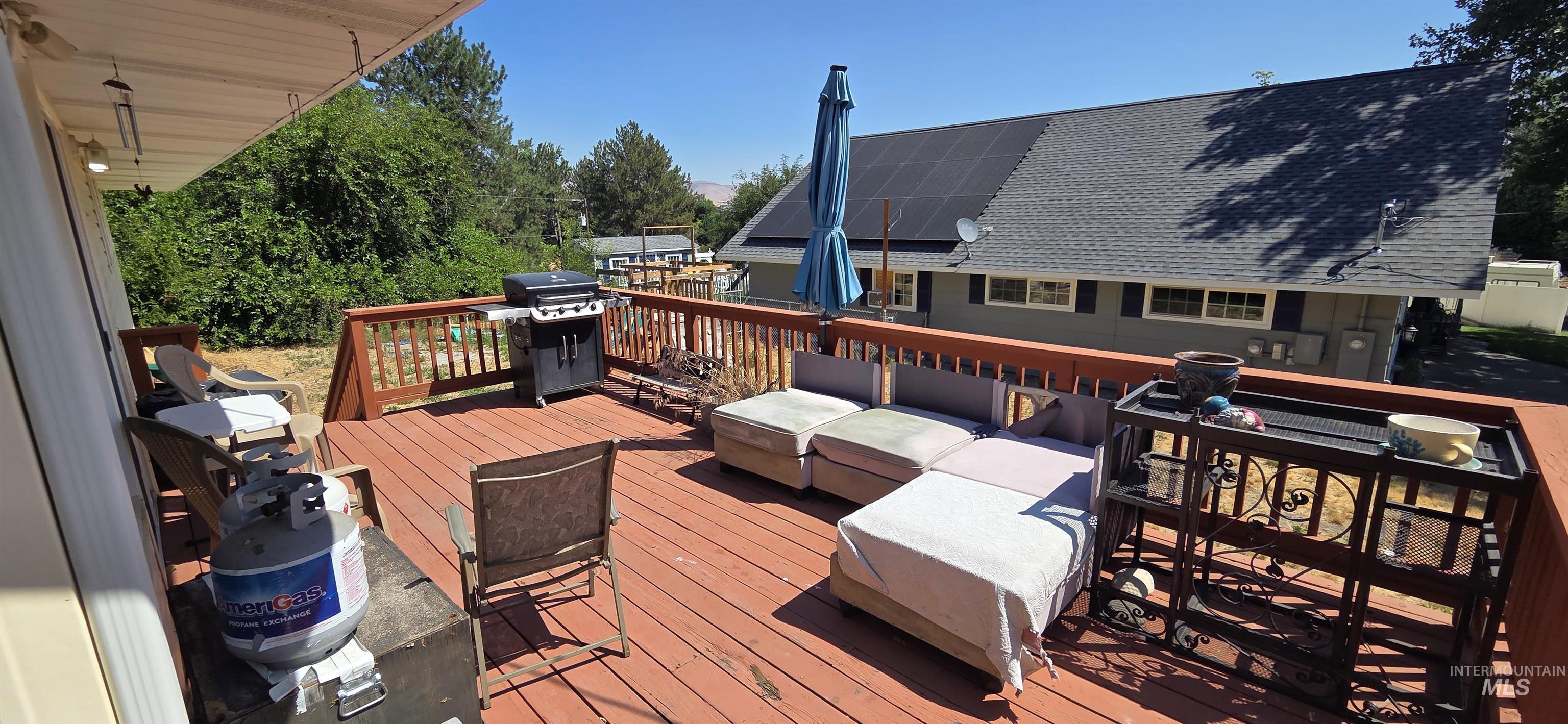 Wooden terrace featuring a grill and an outdoor hangout area