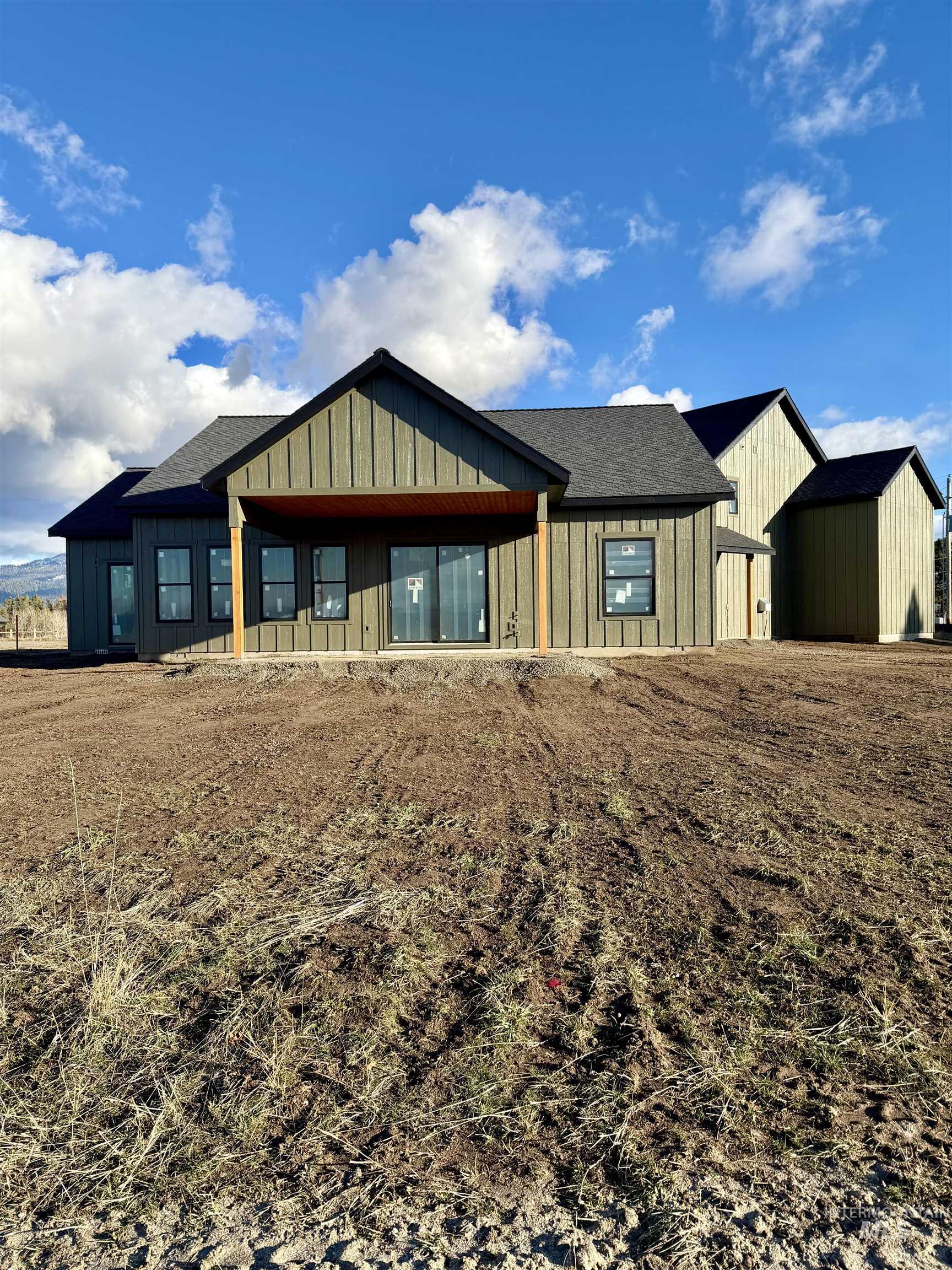View of front facade with board and batten siding, a porch, and a shingled roof