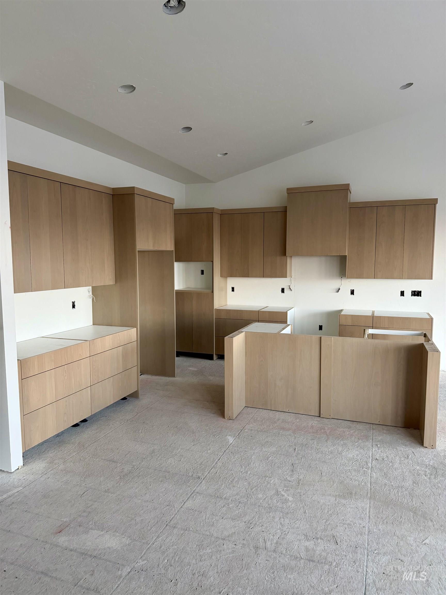 Kitchen with modern cabinets, lofted ceiling, and brown cabinets