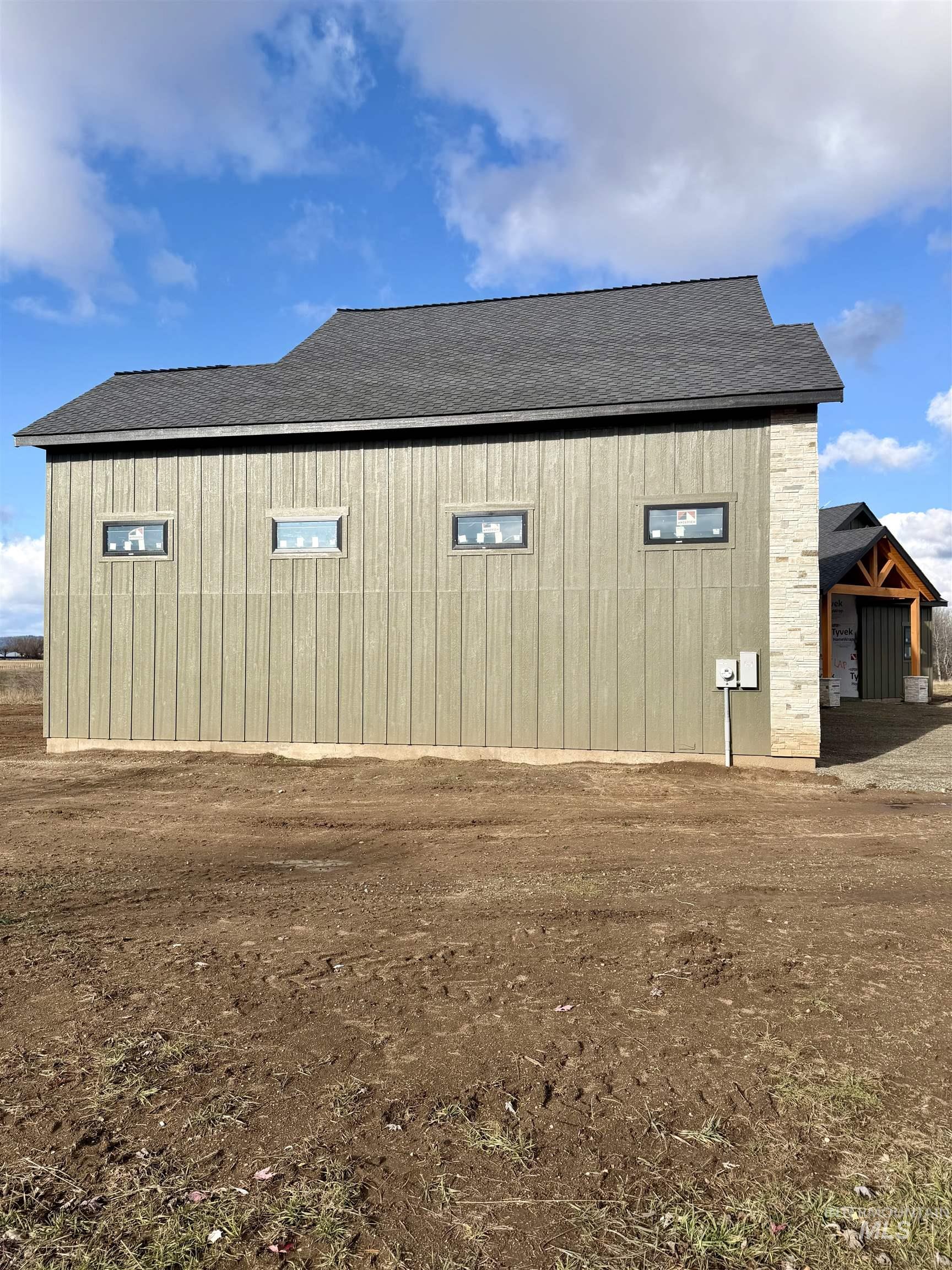 View of side of home with roof with shingles