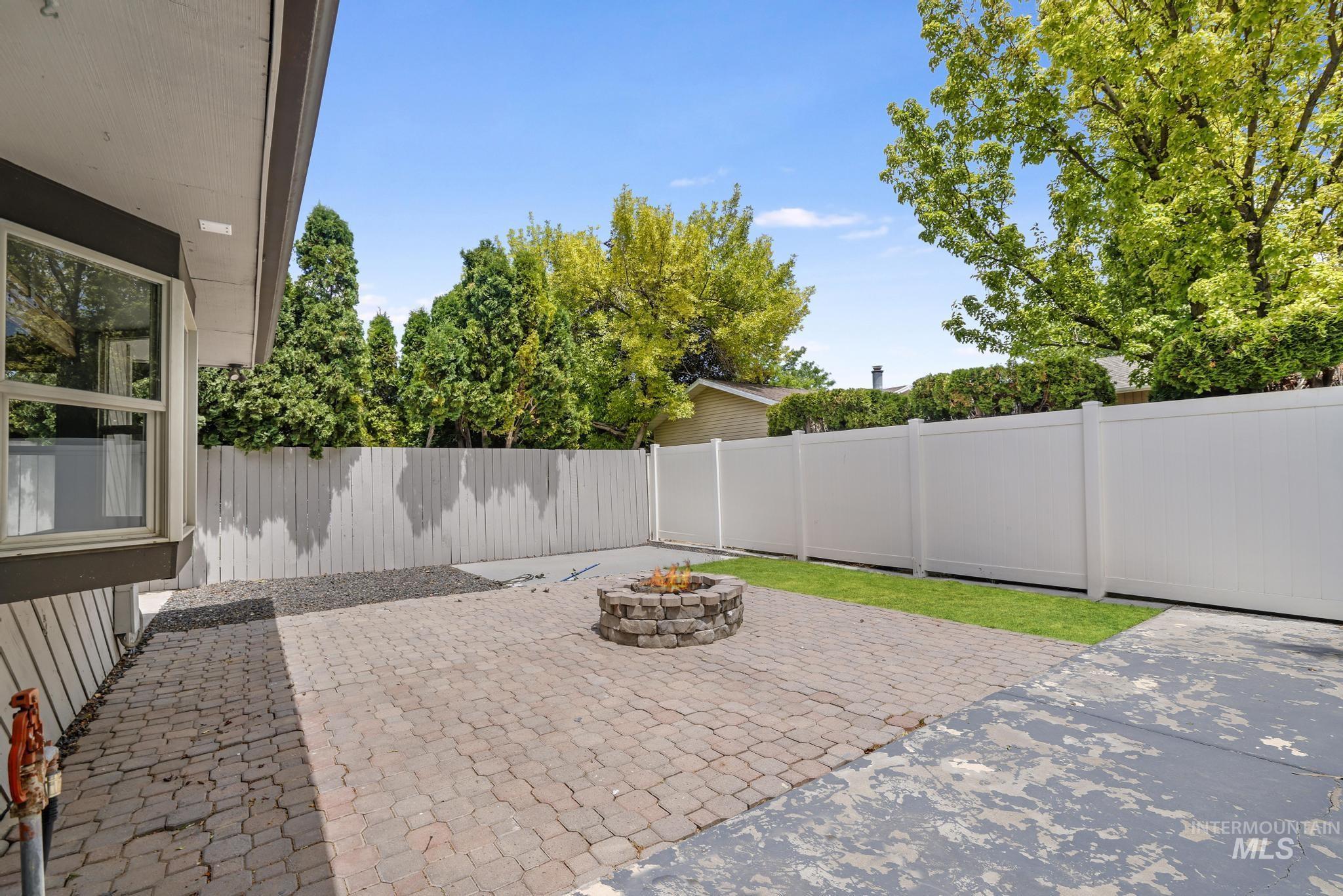 Fenced backyard with a patio area and a fire pit