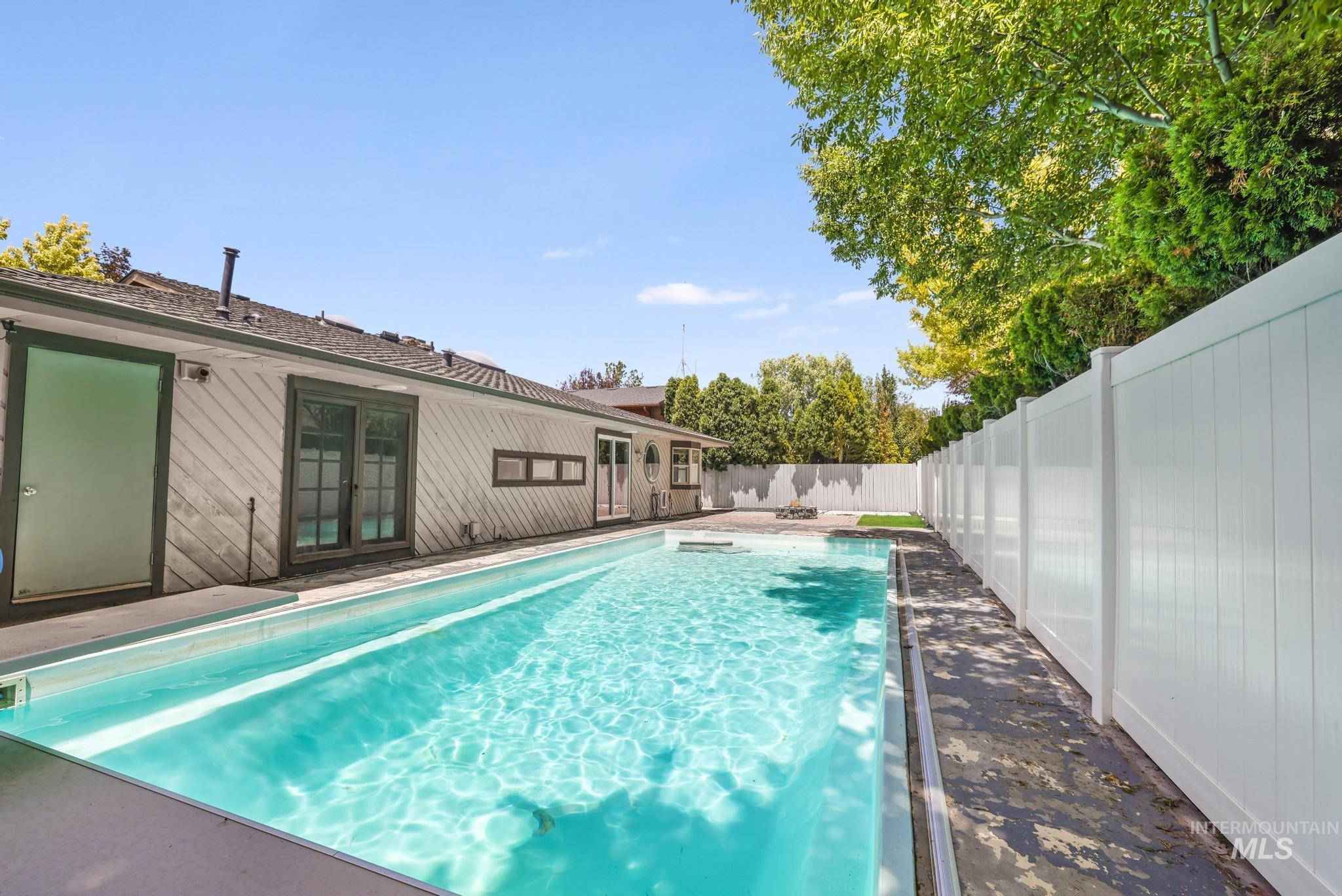 View of swimming pool featuring french doors and a fenced backyard