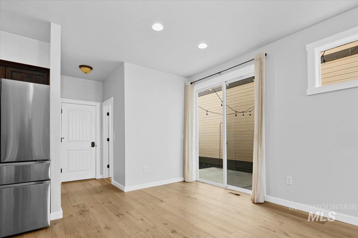 Unfurnished dining area with light wood-style flooring and recessed lighting