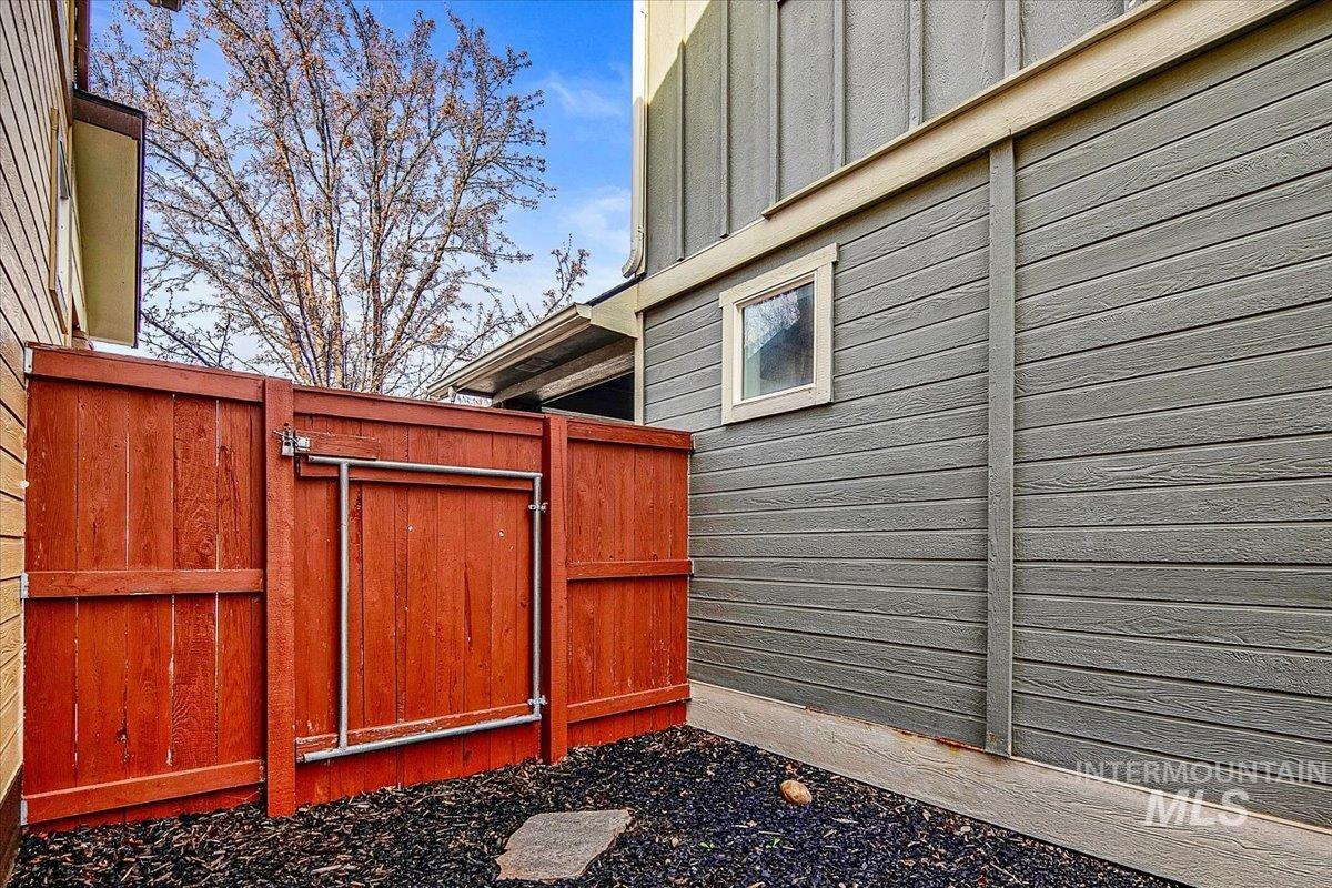 View of side of property with a gate and board and batten siding