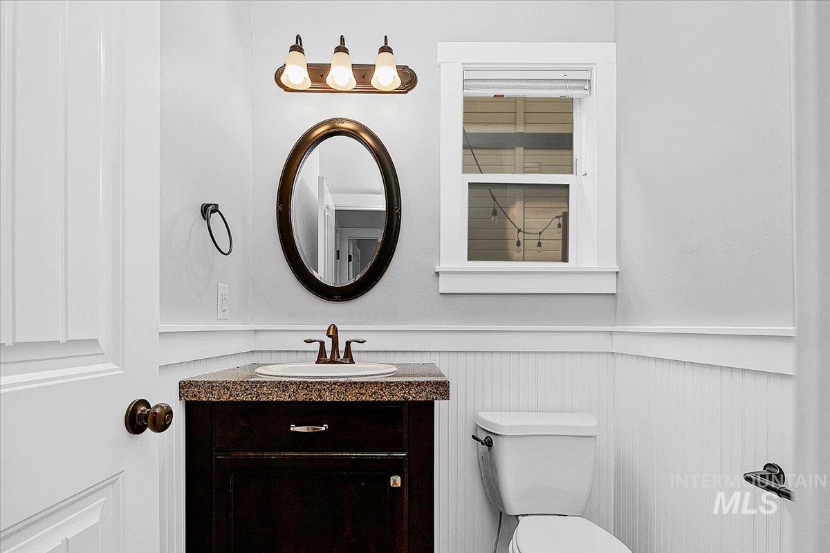Half bathroom with wainscoting and vanity
