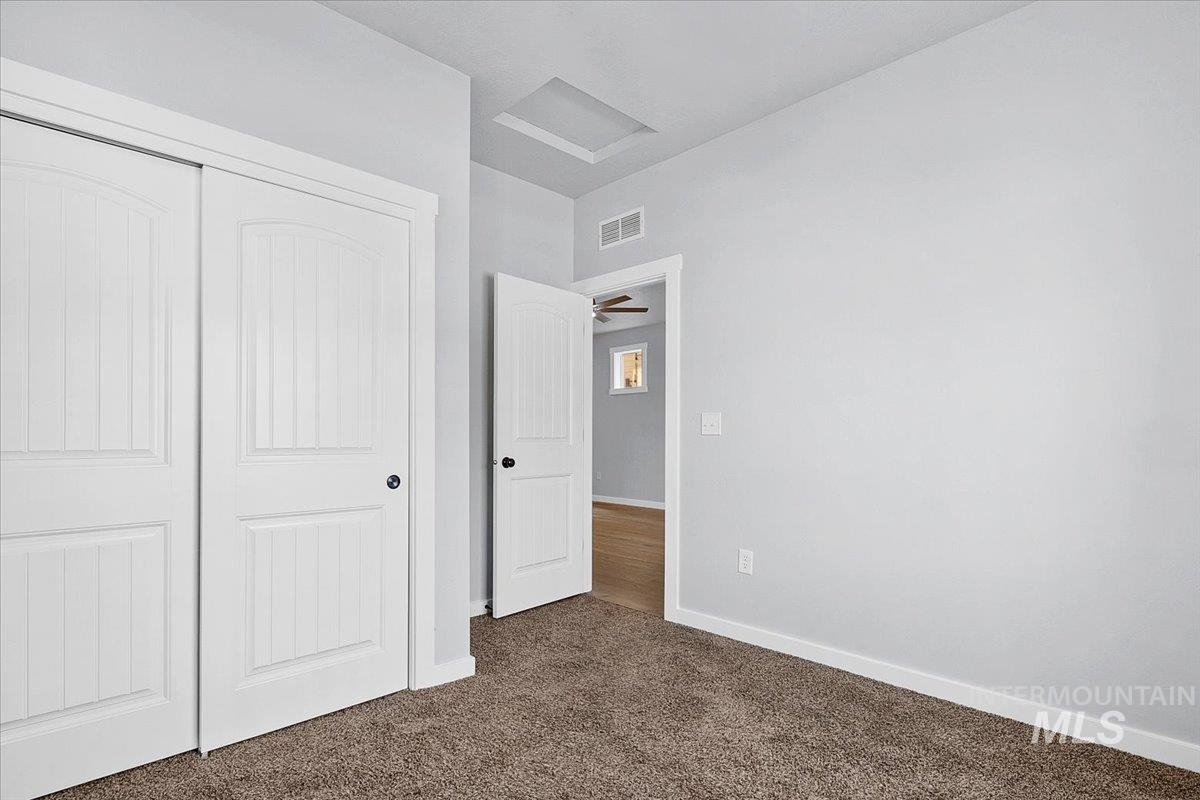 Unfurnished bedroom featuring a closet and dark colored carpet