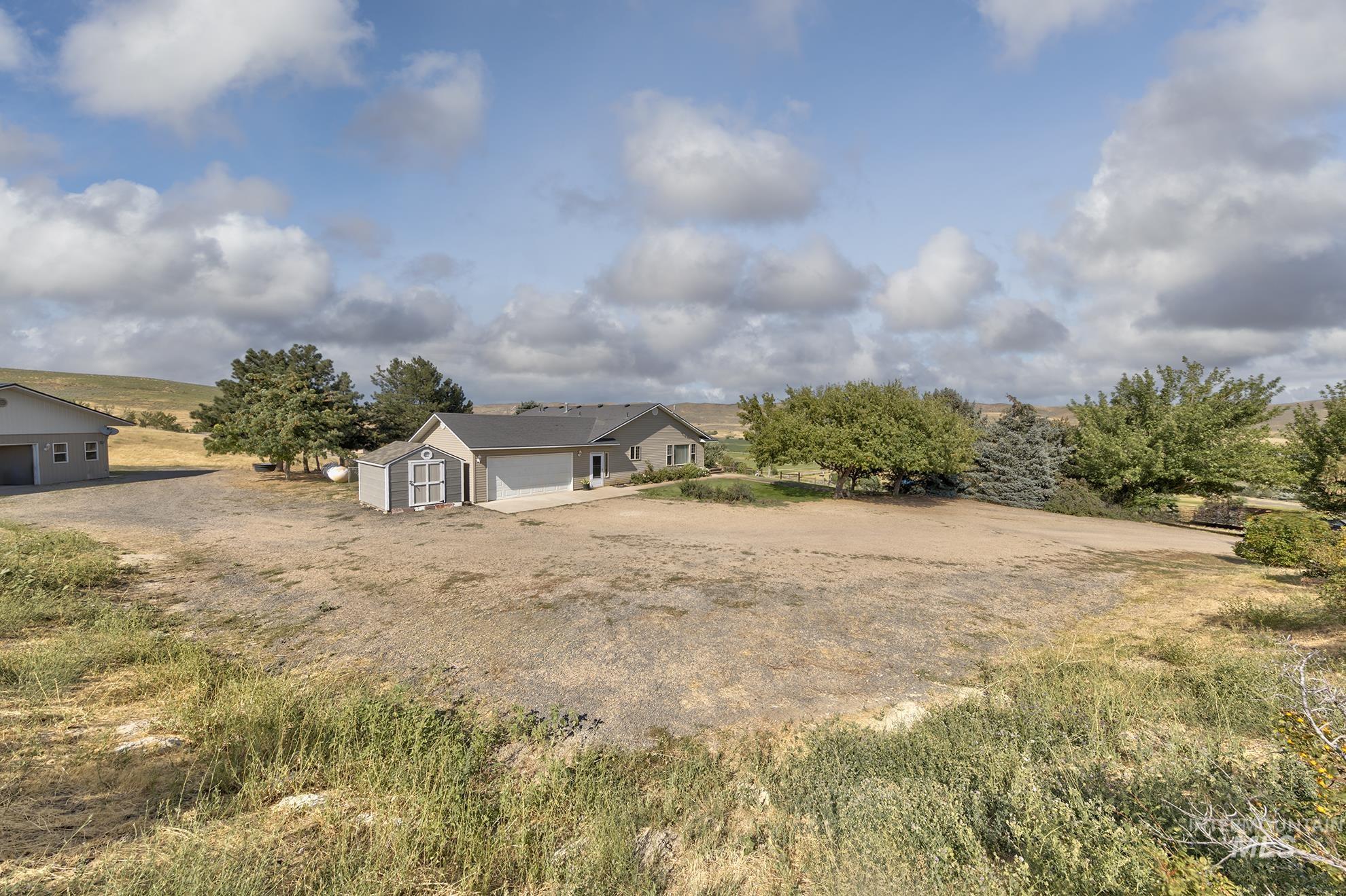 View of yard featuring dirt driveway and a rural view