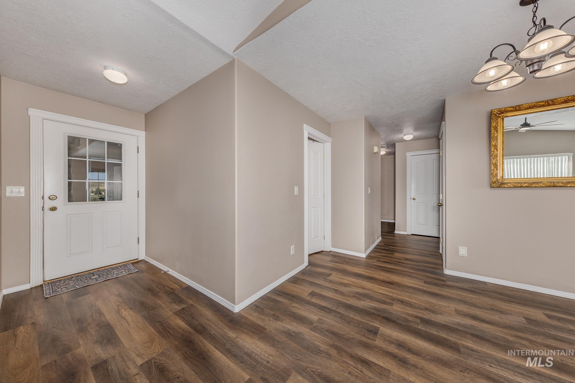 Foyer featuring dark wood-style floors, a textured ceiling, and ceiling fan
