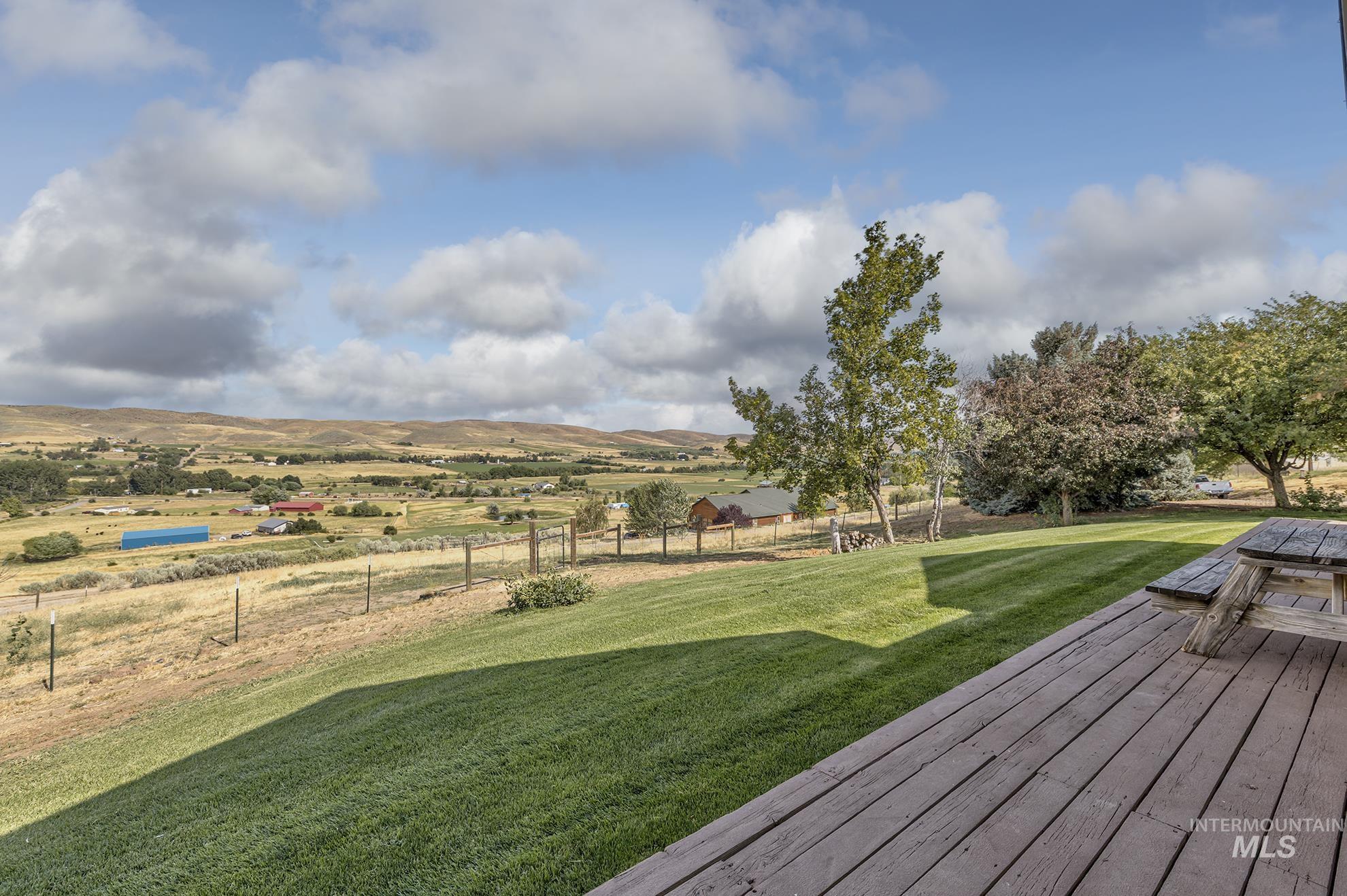 View of yard with a wooden deck and a rural view