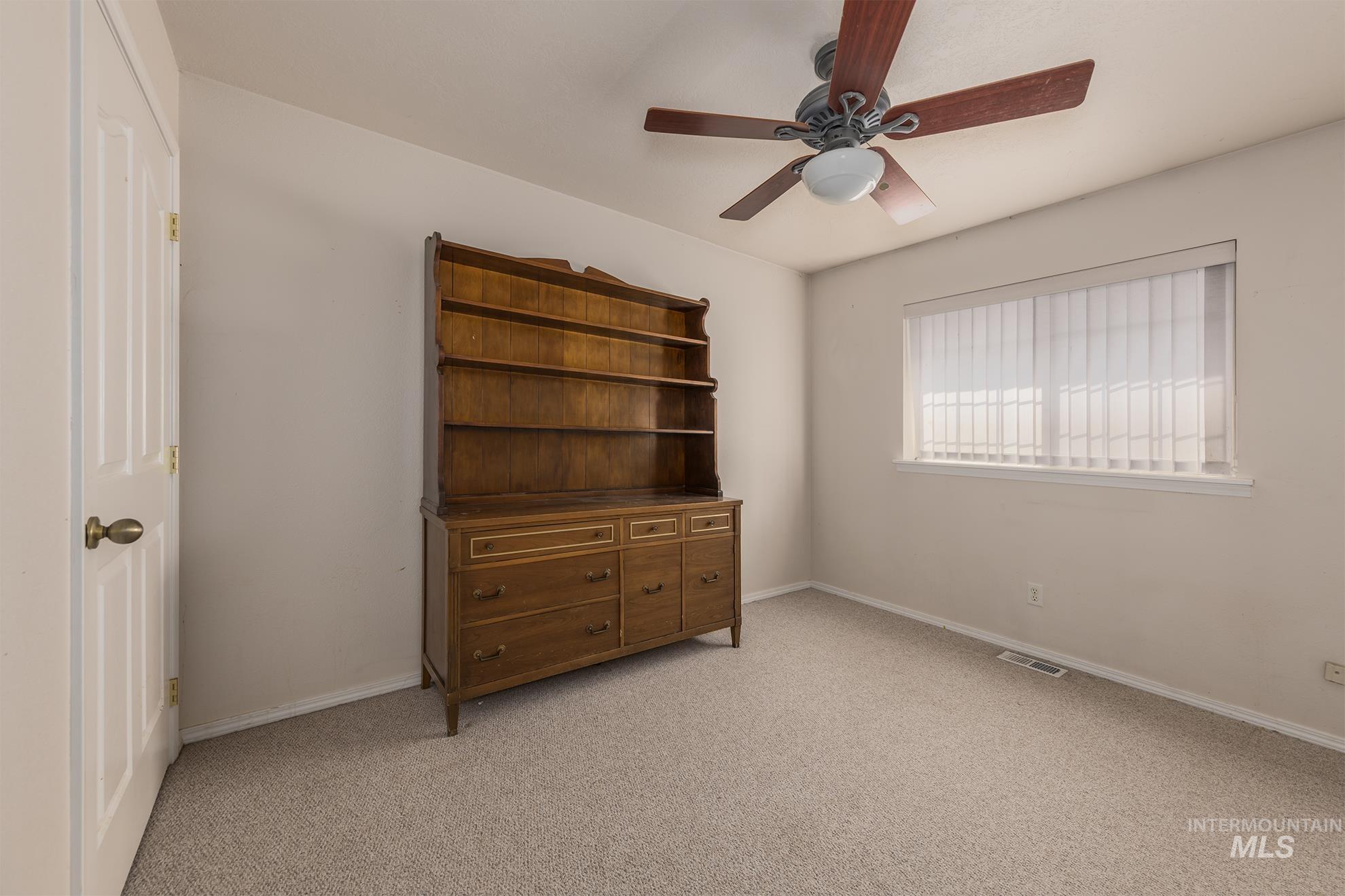 Bedroom featuring light colored carpet and a ceiling fan